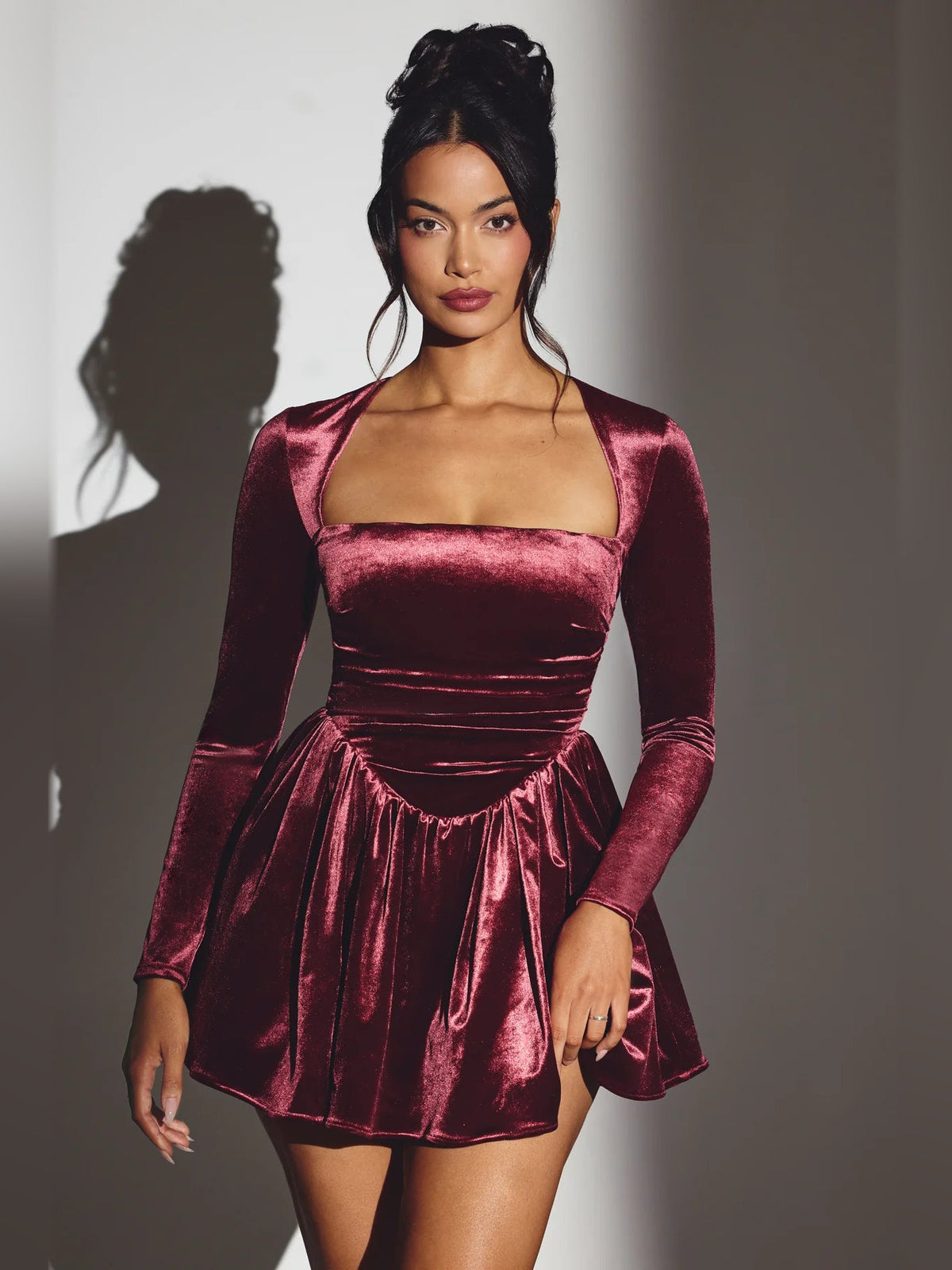 Wine velvet long-sleeve mini dress with square neckline and ruched corset waist.