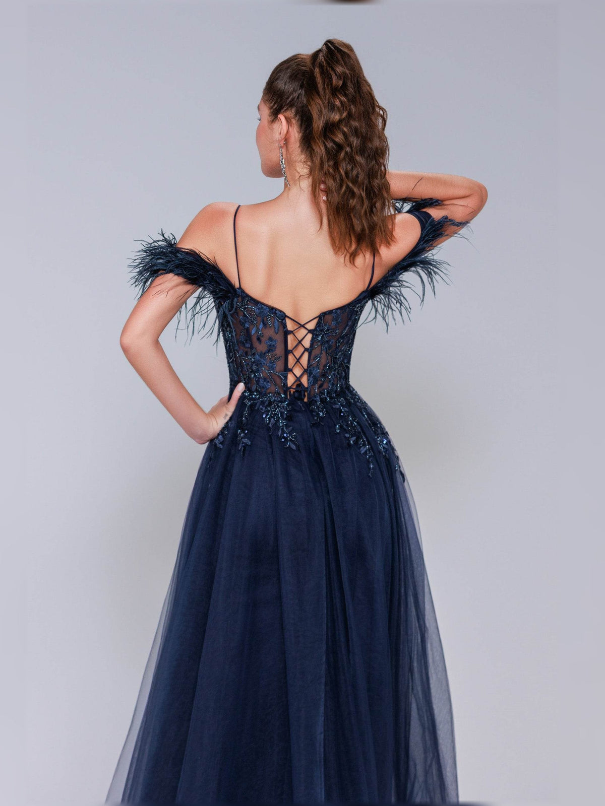 Navy open-back corset formal dress with feather shoulder trim and glittering bodice