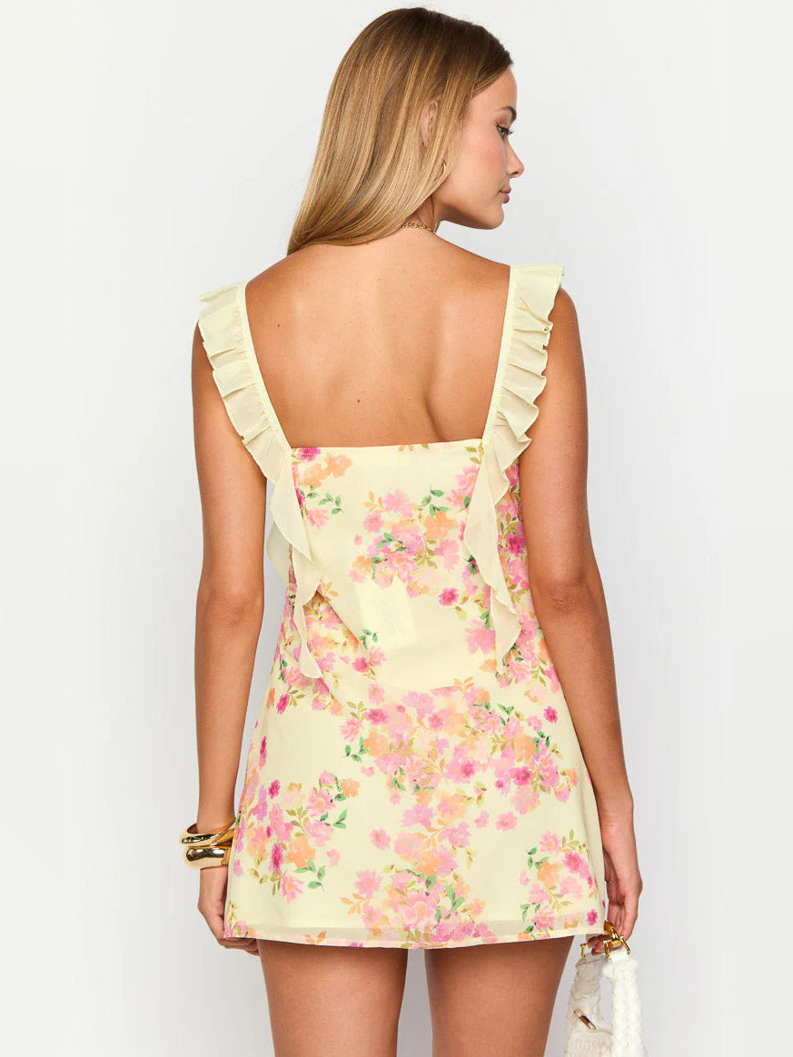 Back view of yellow floral mini dress with ruffled straps and fitted straight bodice