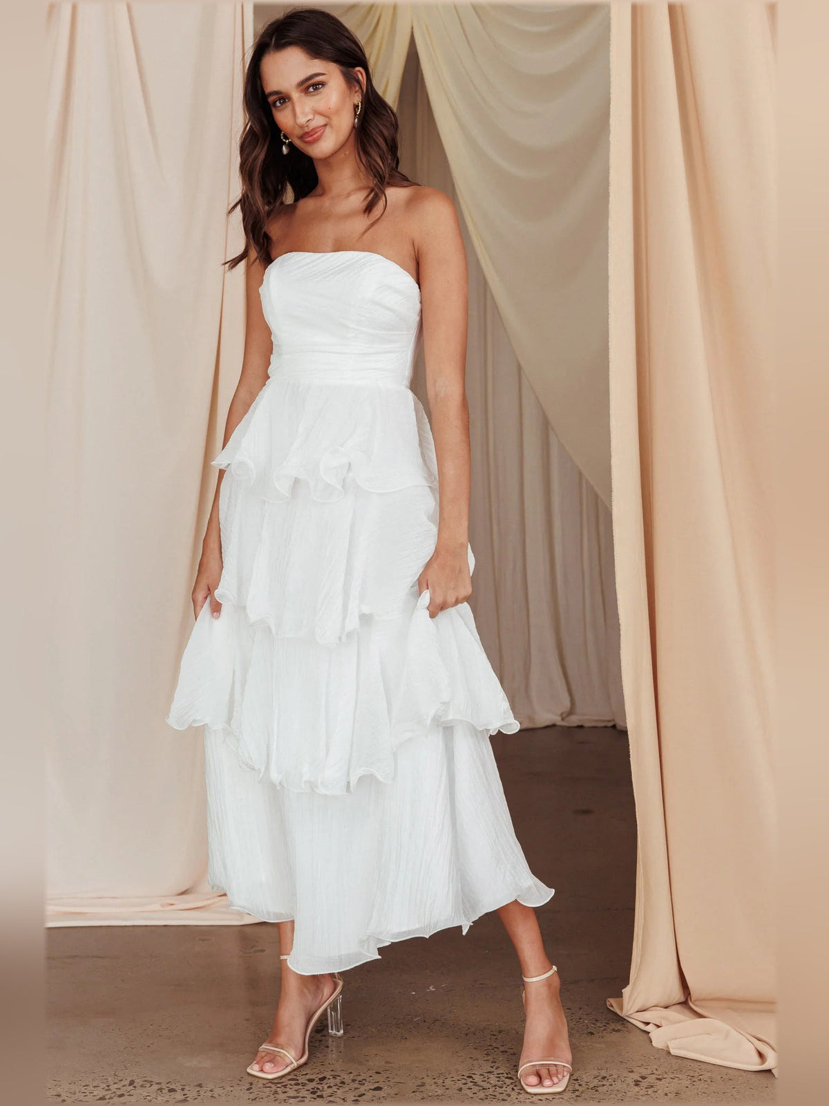 Off-white strapless layered midi formal dress with tiered ruffle skirt, angled view