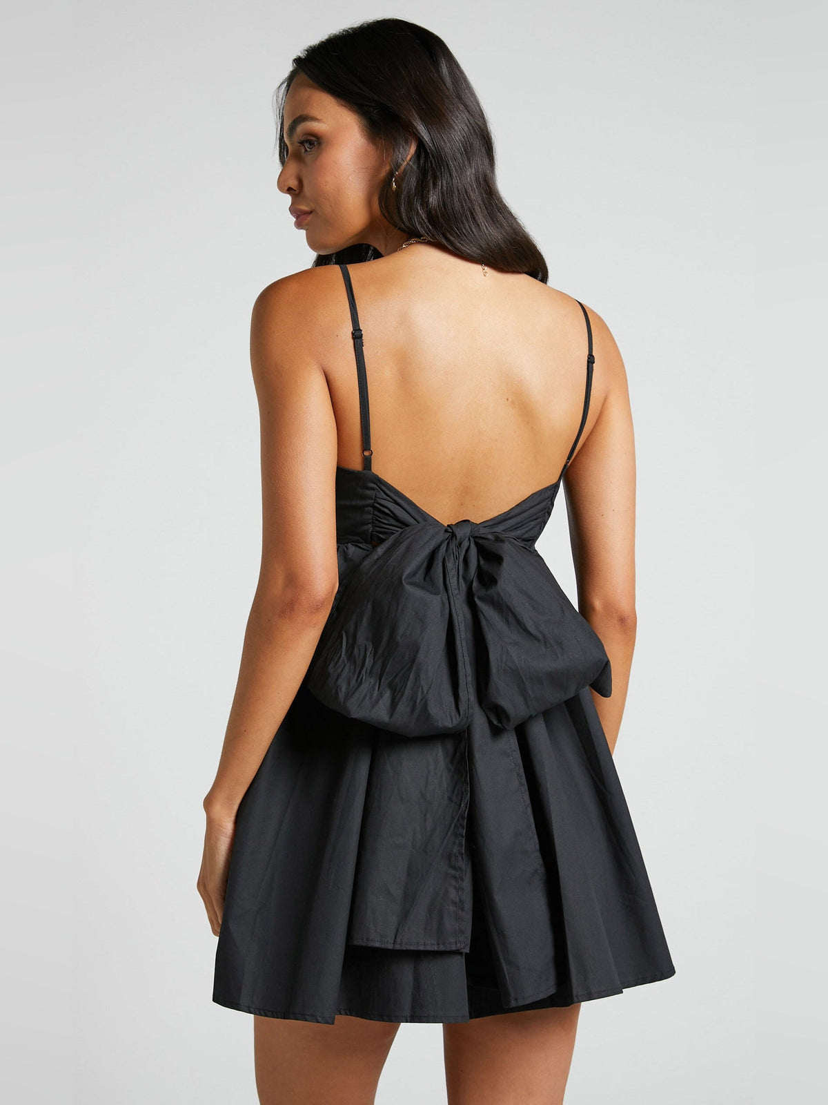 Black mini dress with back bow detail and gathered skirt
