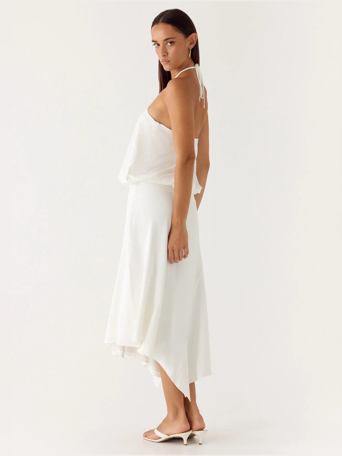 White midi formal dress with halter tie back, sleeveless drape, asymmetrical hem