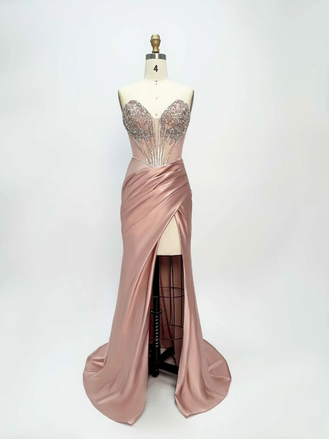 Dusty pink satin prom dress on mannequin with corset back and thigh slit