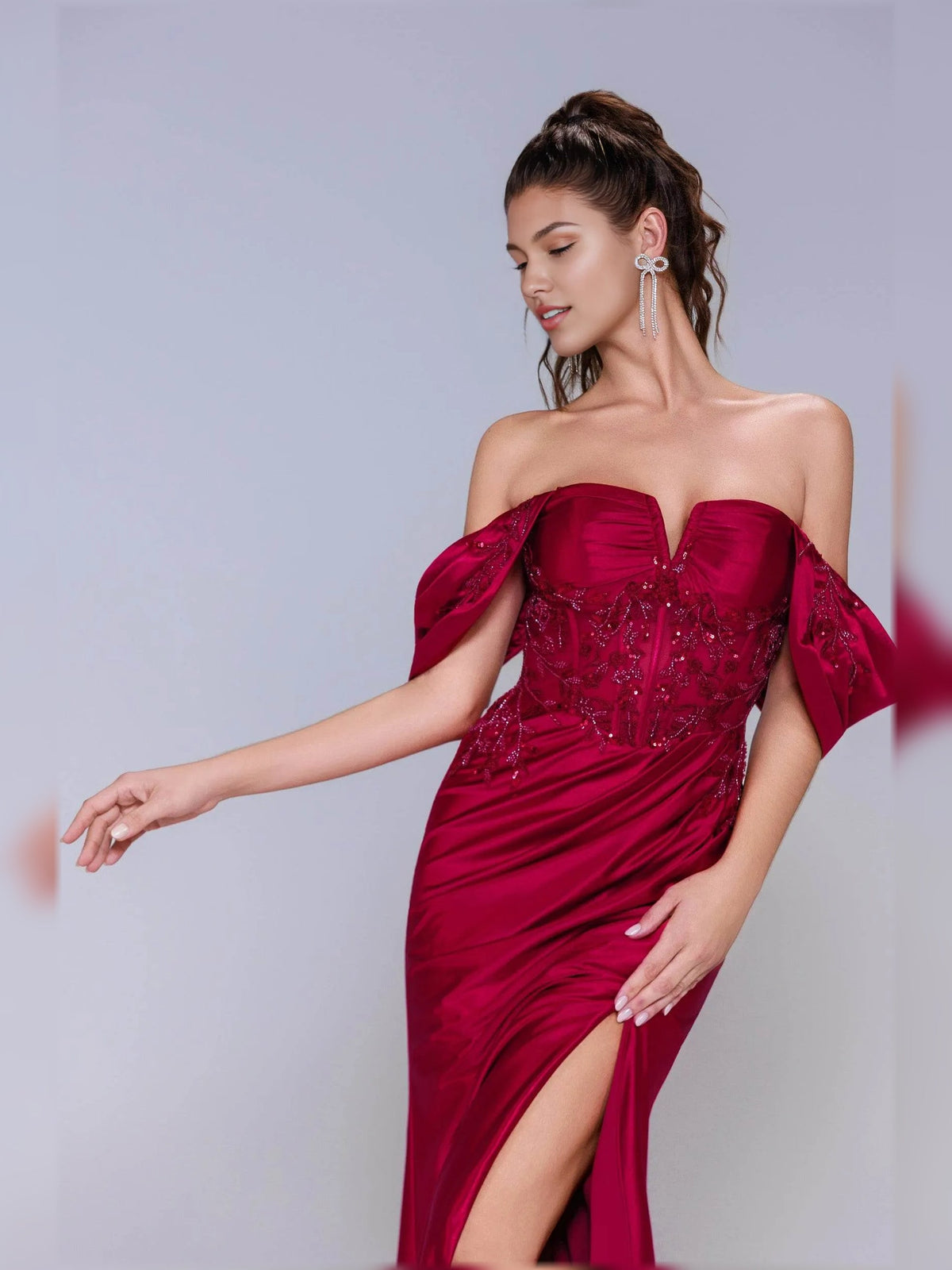 Deep red off-shoulder formal dress with ruched satin skirt and front slit detail.