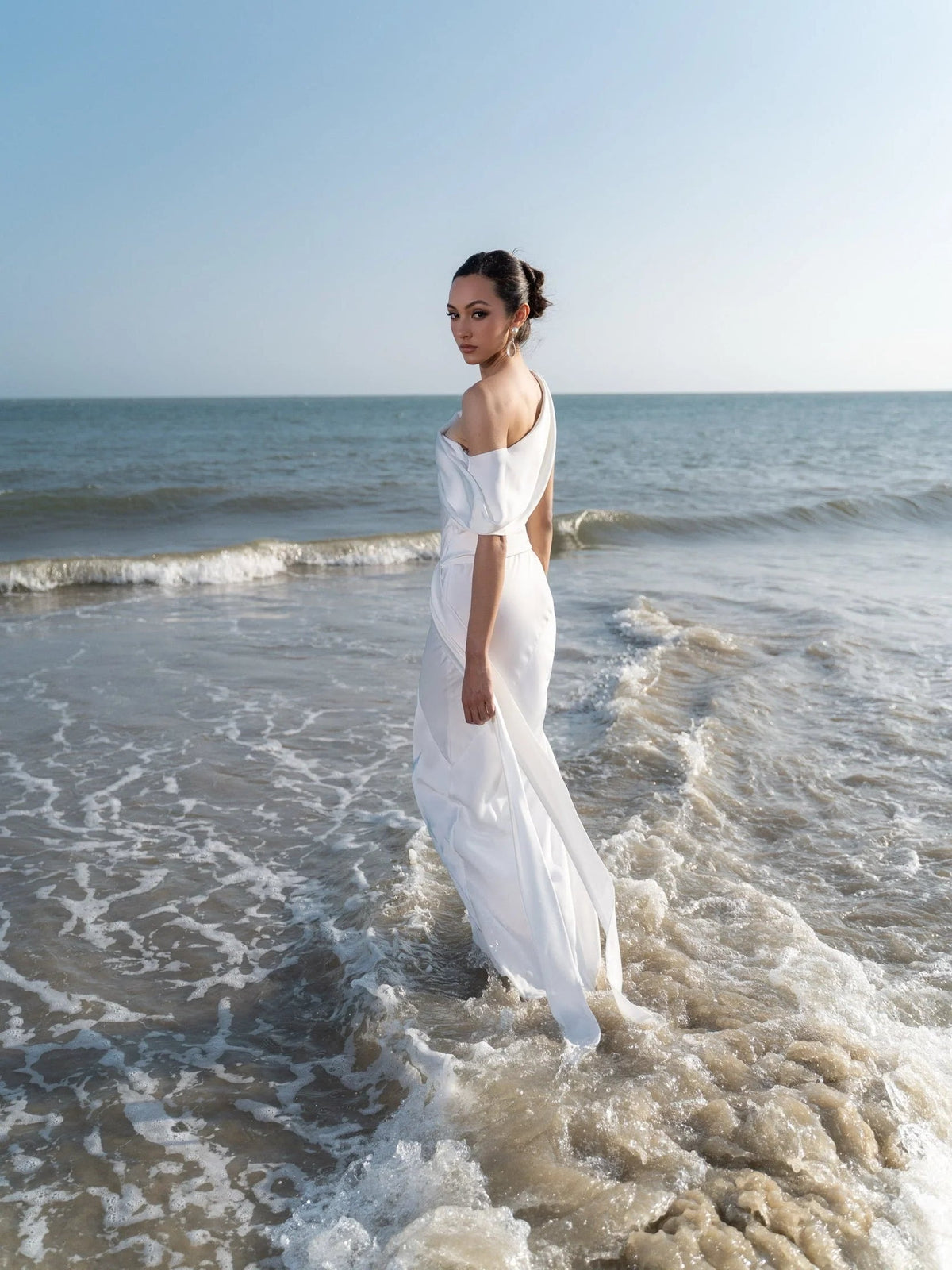 White satin midi sheath dress with halter neckline and draped wrap at the waist