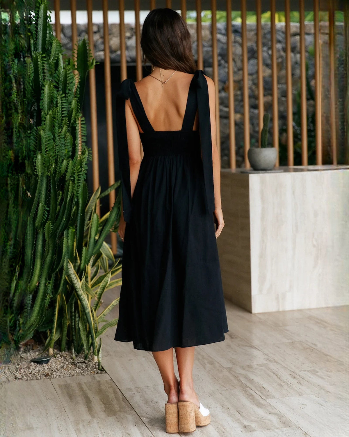 Black sleeveless A-line midi dress back view with open back and bow tie straps