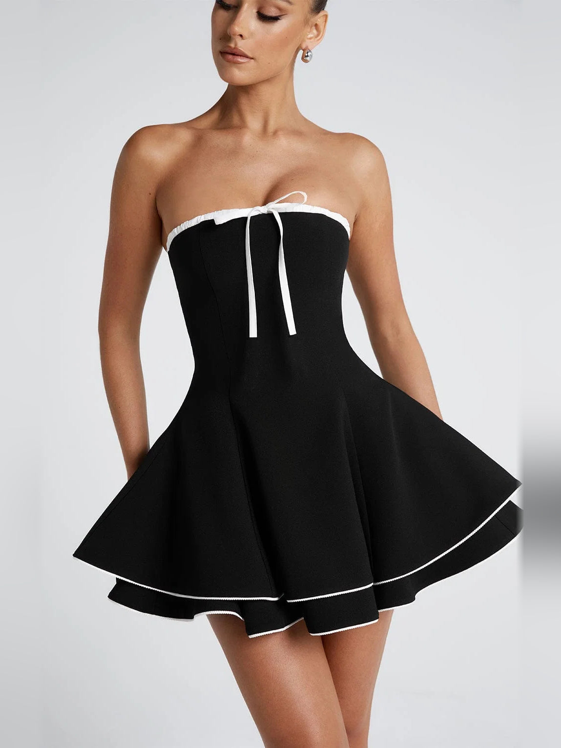 Mini homecoming dress: strapless black with white trim, ribbon tie at bust, pleated flared skirt