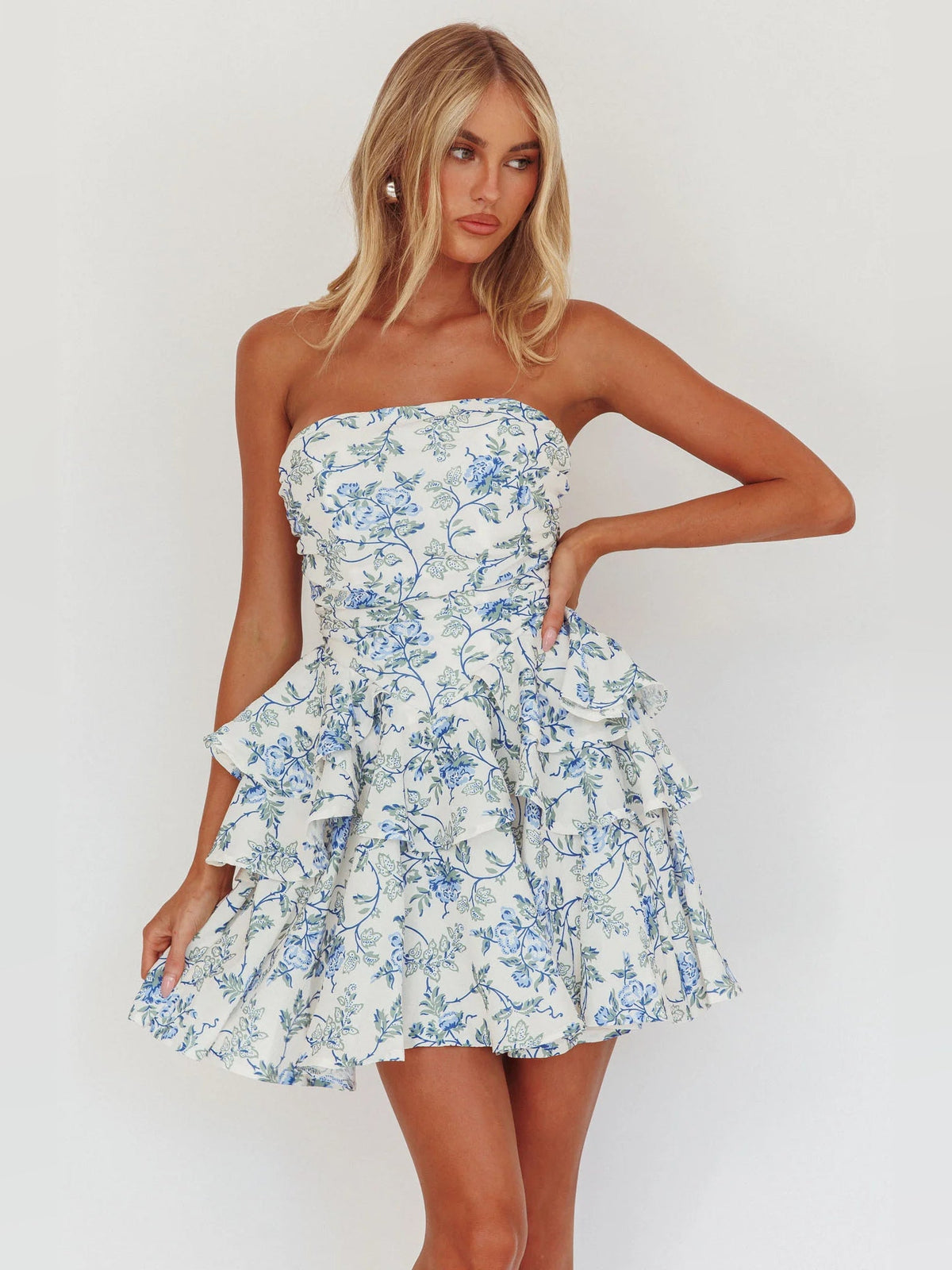 Blue floral strapless mini dress with layered ruffle skirt and gathered waist seam.
