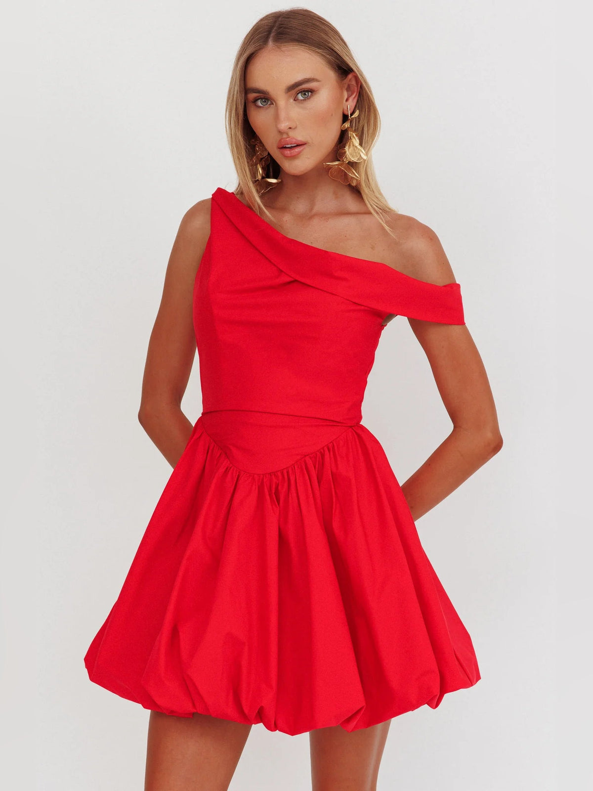 Front view: red asymmetrical mini homecoming dress with diagonal neckline and gathered waist