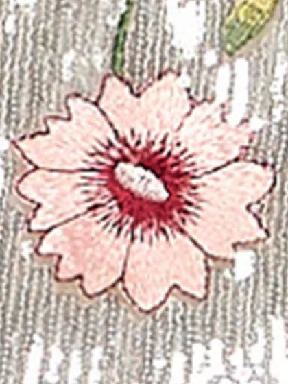 Embroidered floral detail on a light gray formal dress, pink flower with dark center