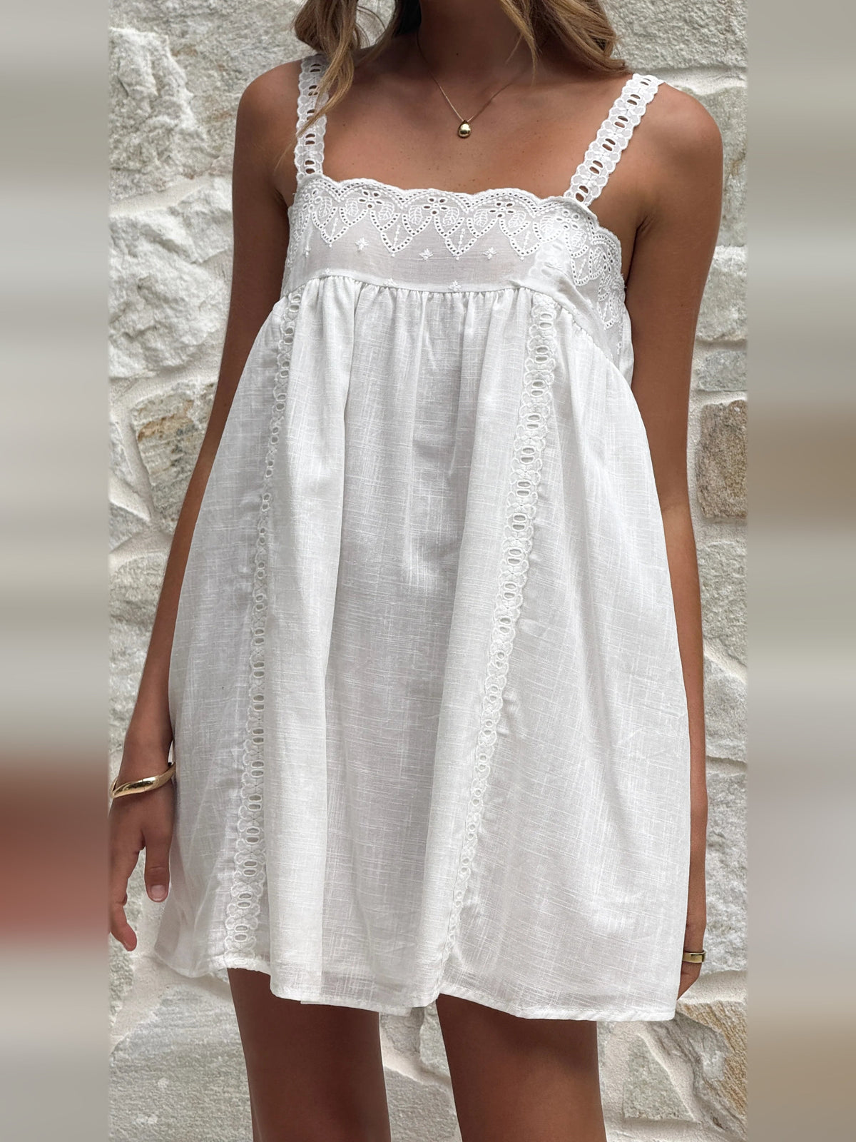 White mini dress bodice with lace trim, eyelet panel, and gathered skirt