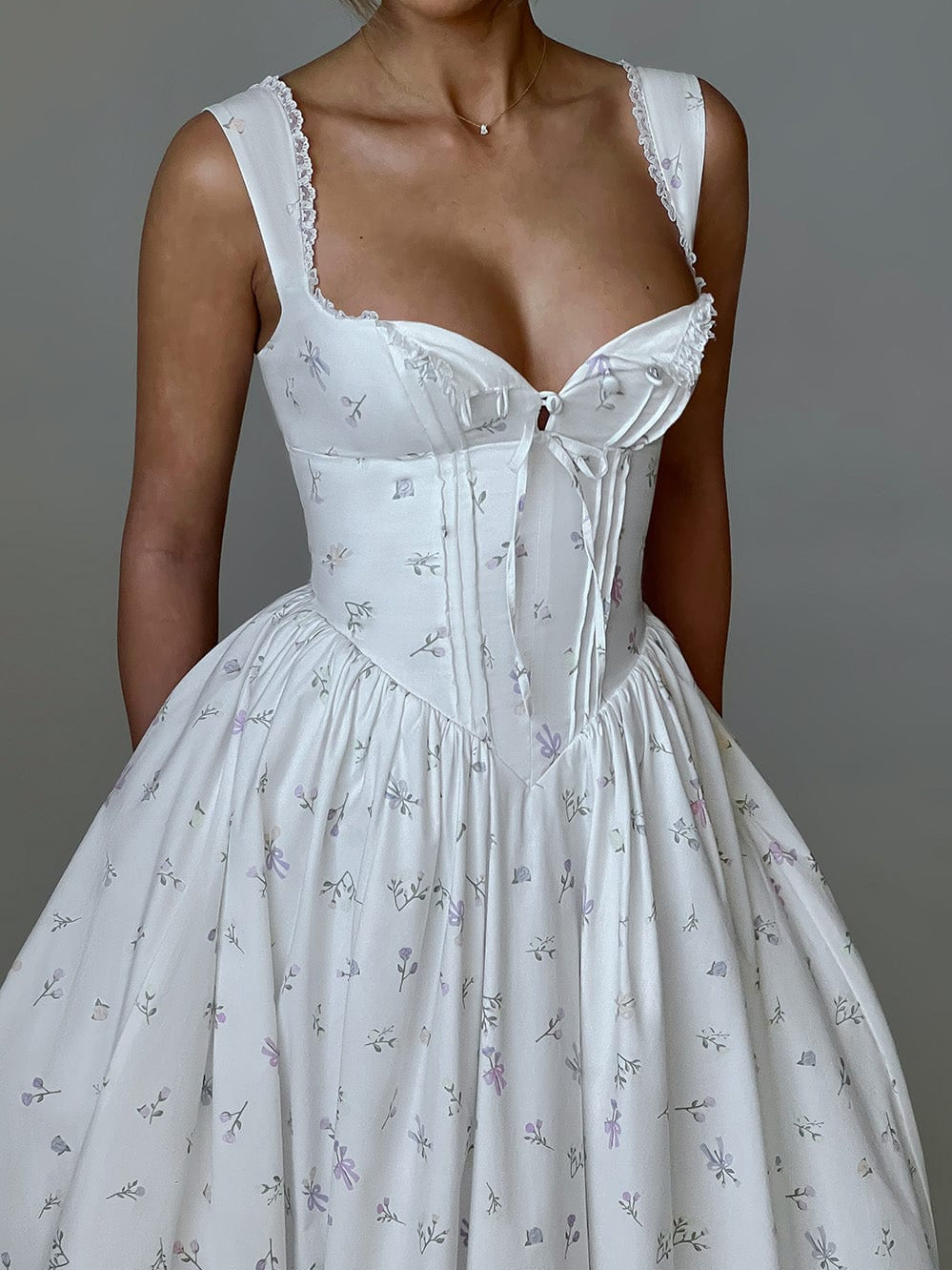 White corset-style midi dress bodice with sweetheart neckline, lace trim, bow accents, printed fabric