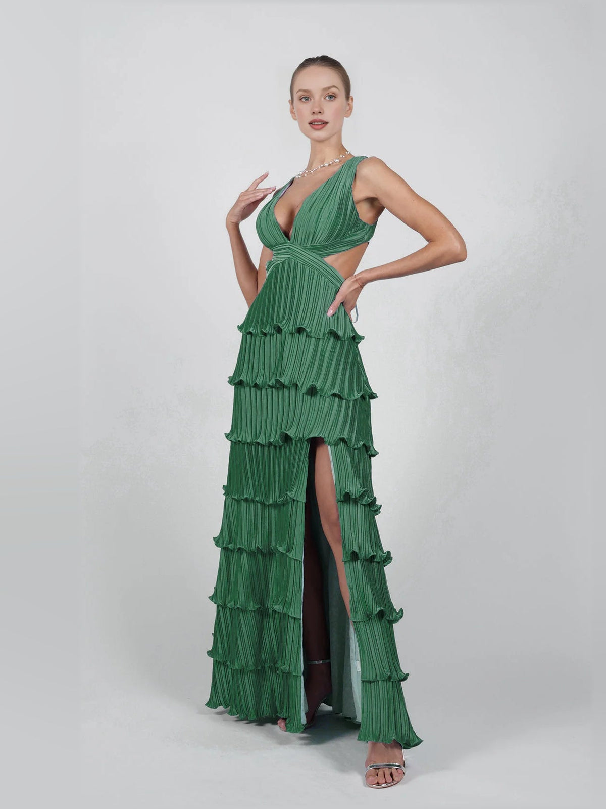 Green v-neck pleated tiered formal dress with side slit and layered ruffle tiers, floor-length.