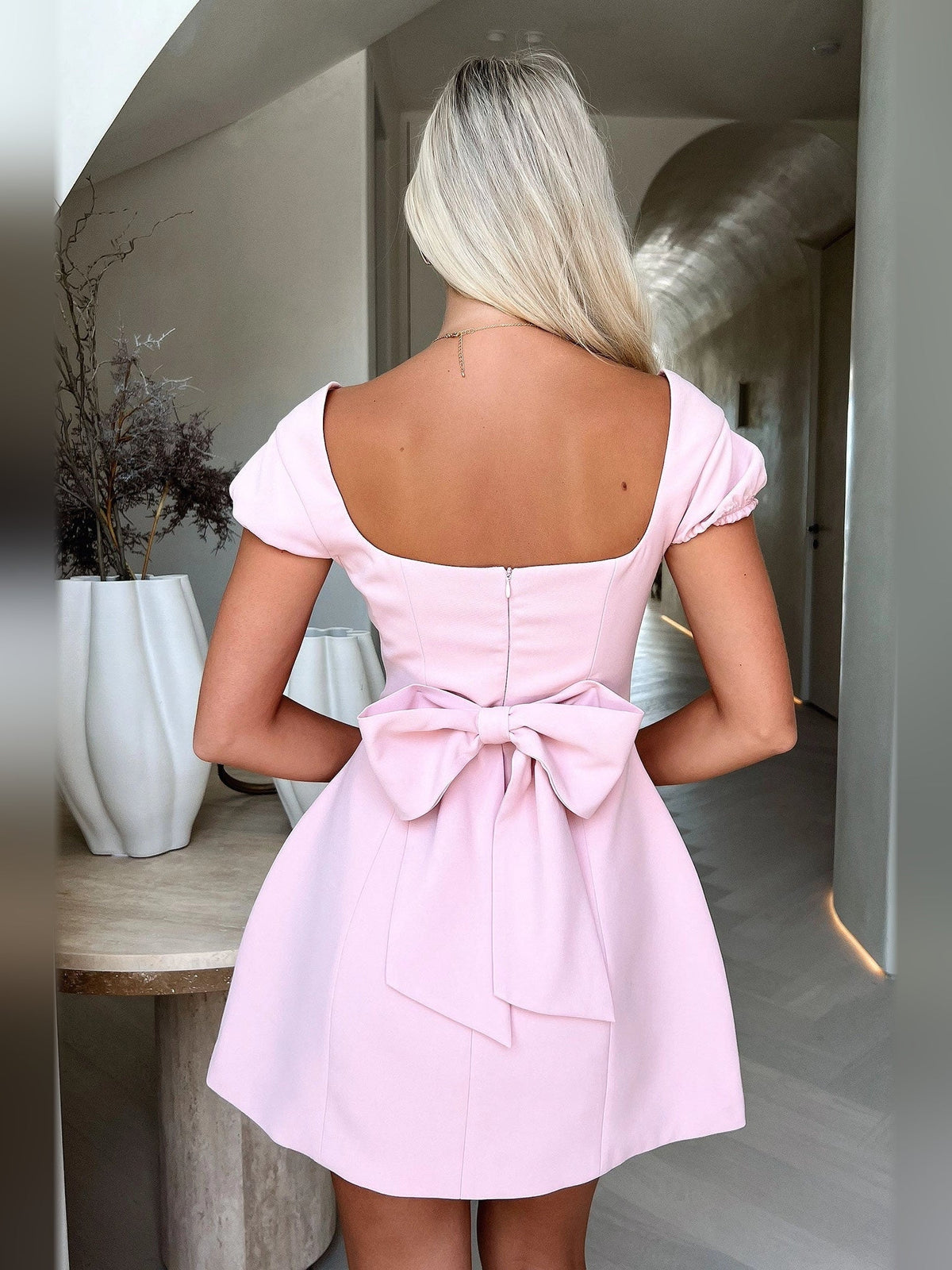 Blush pink A-line mini dress back view with square neckline and tied bow