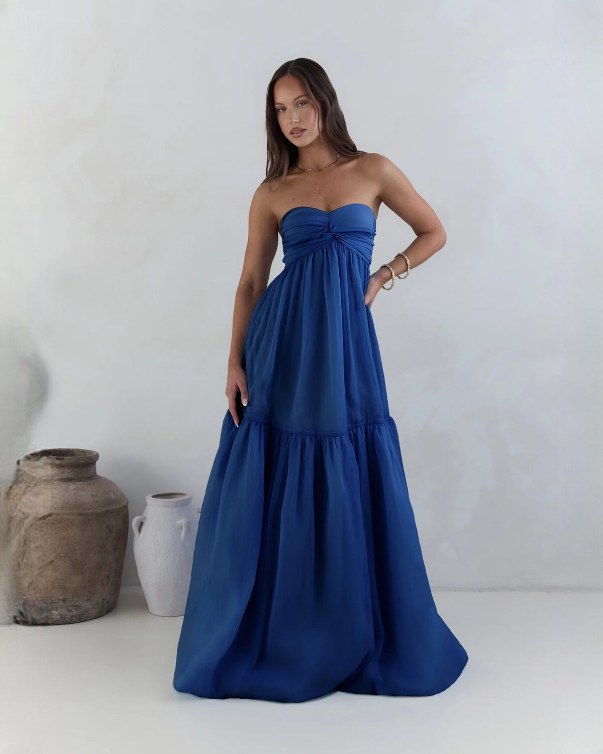Navy strapless satin A-line maxi bridesmaid dress with tiered skirt and gathered bodice