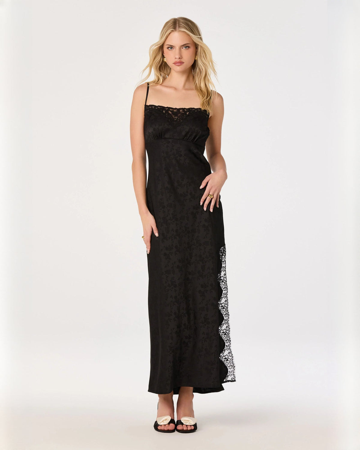 Black sleeveless A-line maxi dress with lace-trim hem and side slit overlay.