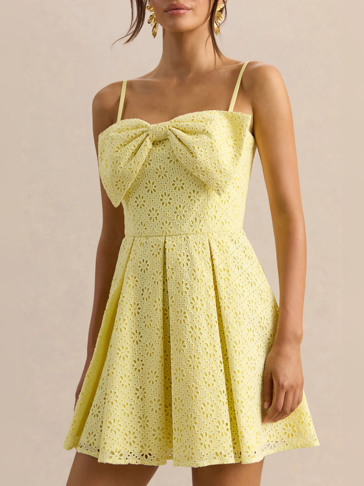 Lemon yellow eyelet bodice mini dress with large bow at neckline and gathered pleated skirt