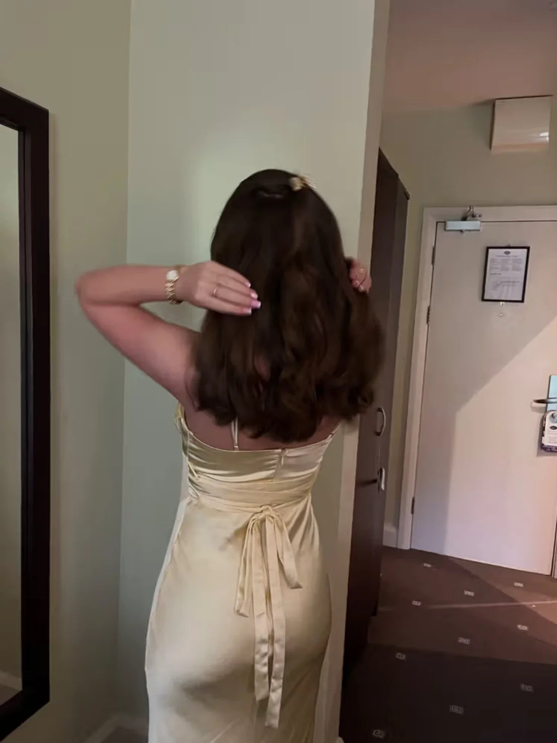 Back view of yellow satin dress with tied bow at waist and ruched center drape