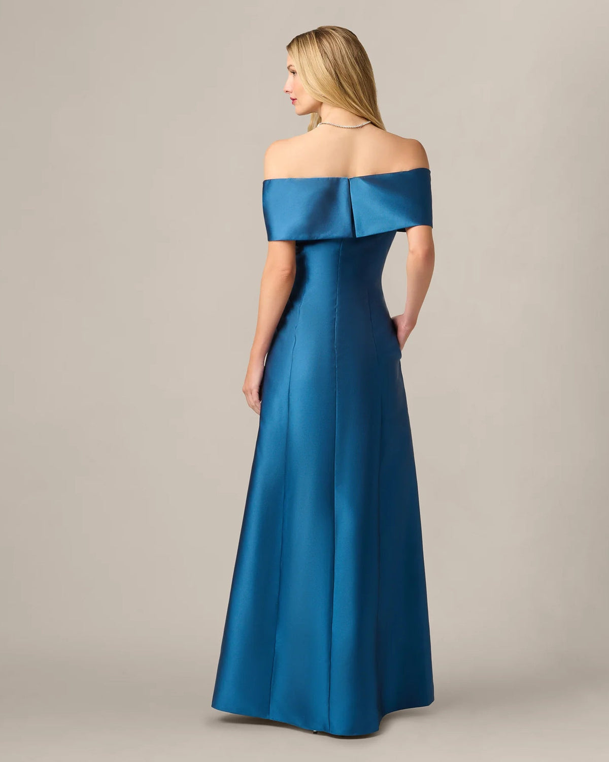 Teal blue off-shoulder A-line maxi dress shown from the back with center seams