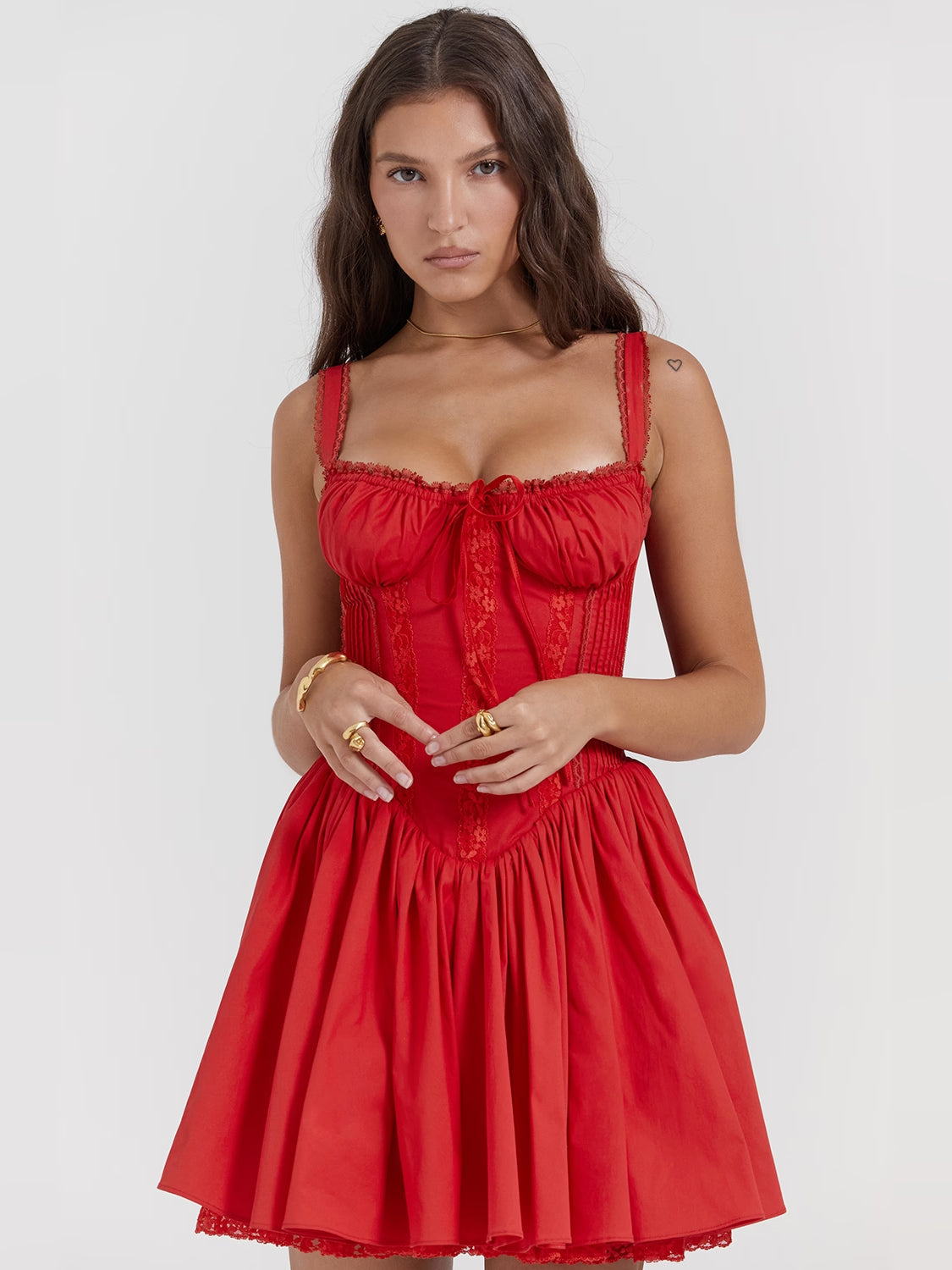 Red corset mini dress close-up: ruched bust, textured bodice, thin straps, tiered skirt