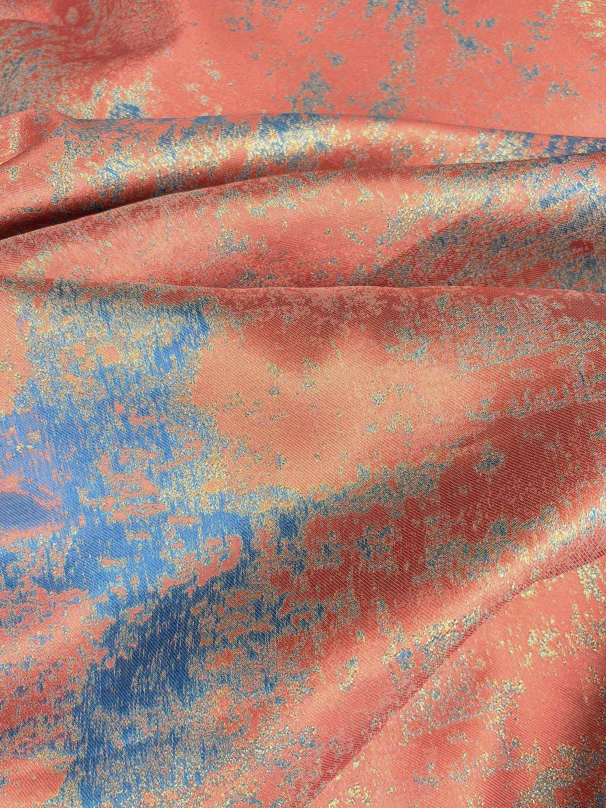 Coral and blue abstract speckled fabric swatch with soft sheen