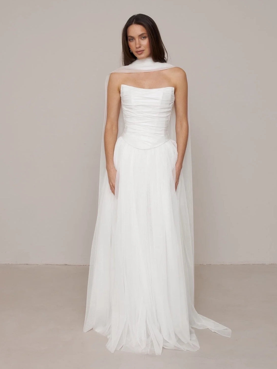 Ivory strapless wedding dress with ruched waist seam and flowing A-line floor-length skirt