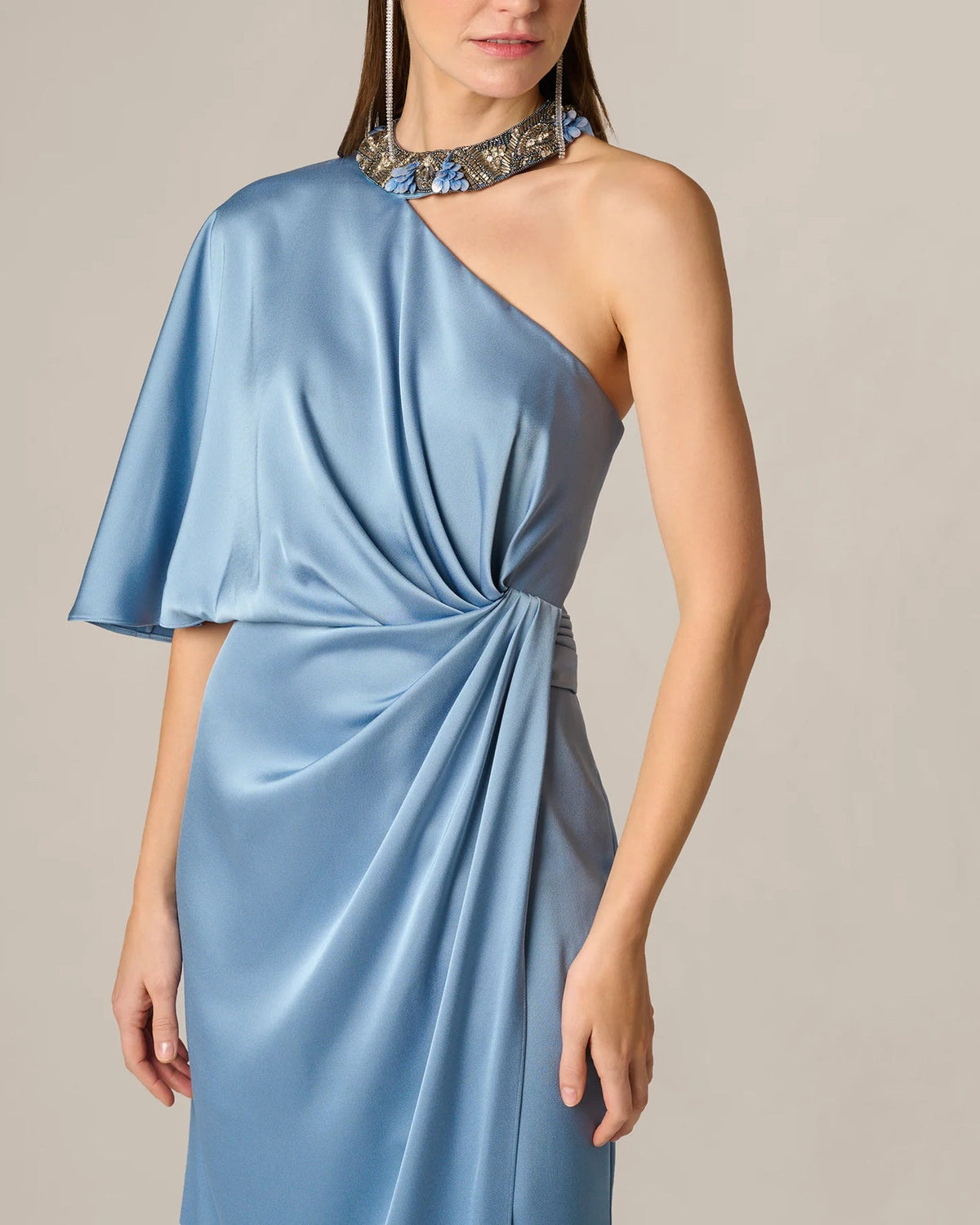 Light blue one-shoulder maxi dress with flutter sleeve, draped front, and jeweled collar