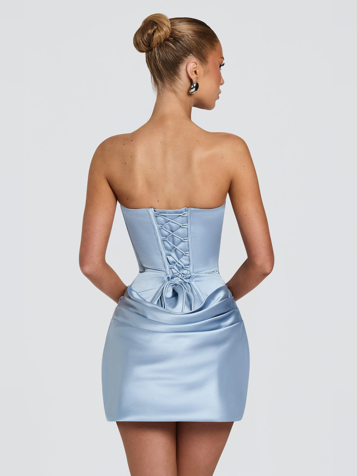 Blue satin mini dress with corset-style lace-up back and gathered drape at hip