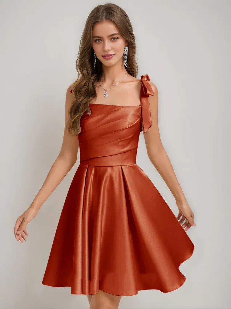 Rust satin corset-style square neck A-line short dress with bow shoulder straps.