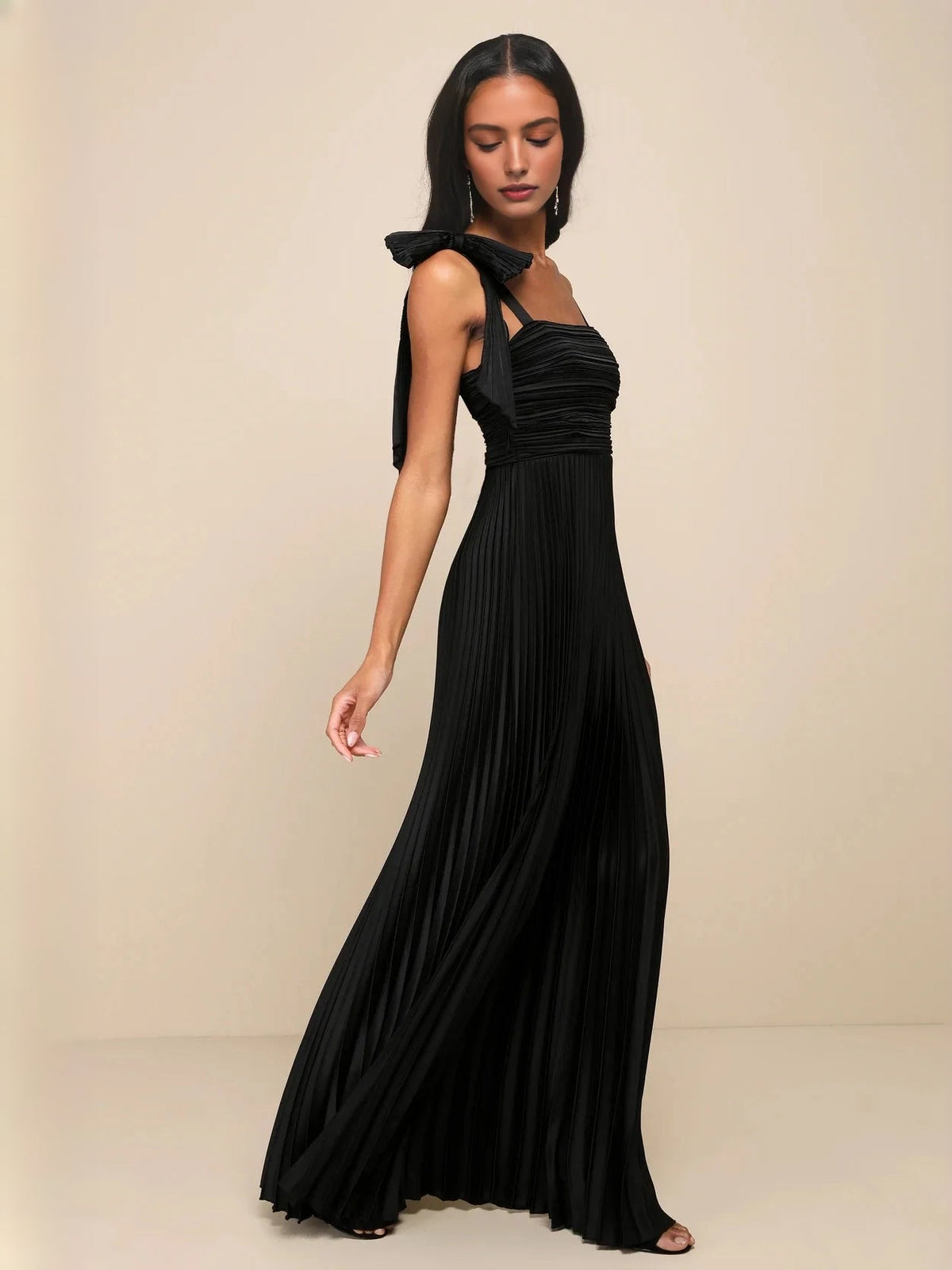 Black satin A-line maxi dress, ruched square-neck bodice, pleated skirt and shoulder bows