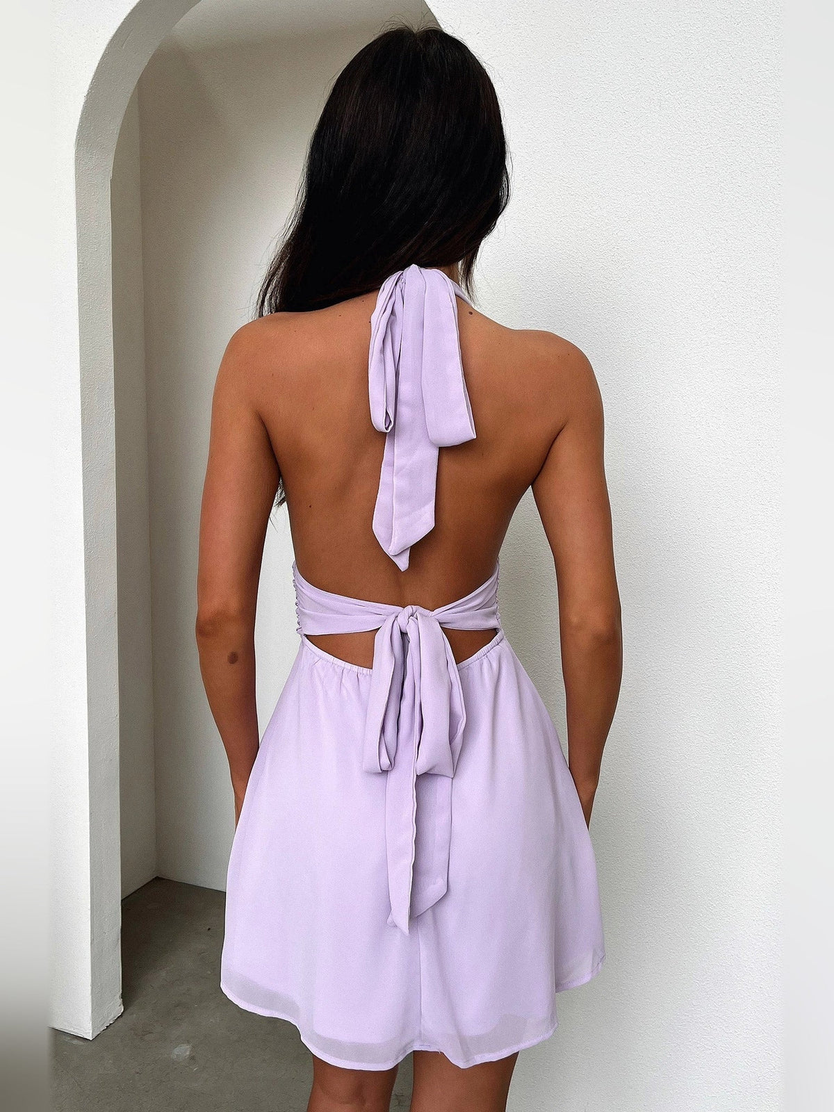 Back view of lavender mini A-line dress with crisscross tie straps and open back
