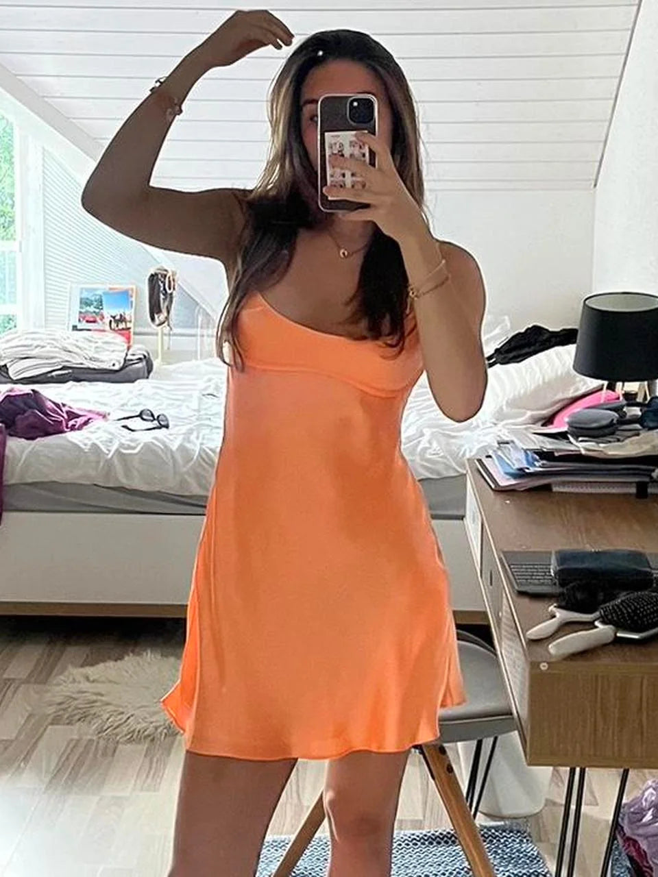 Orange satin mini slip dress with square neckline, thin straps, flared hem.