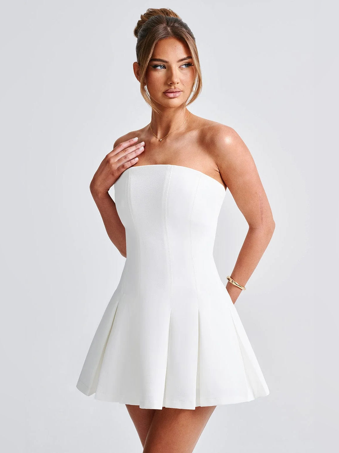 Ivory strapless mini dress with sweetheart neckline and pleated, flared skirt