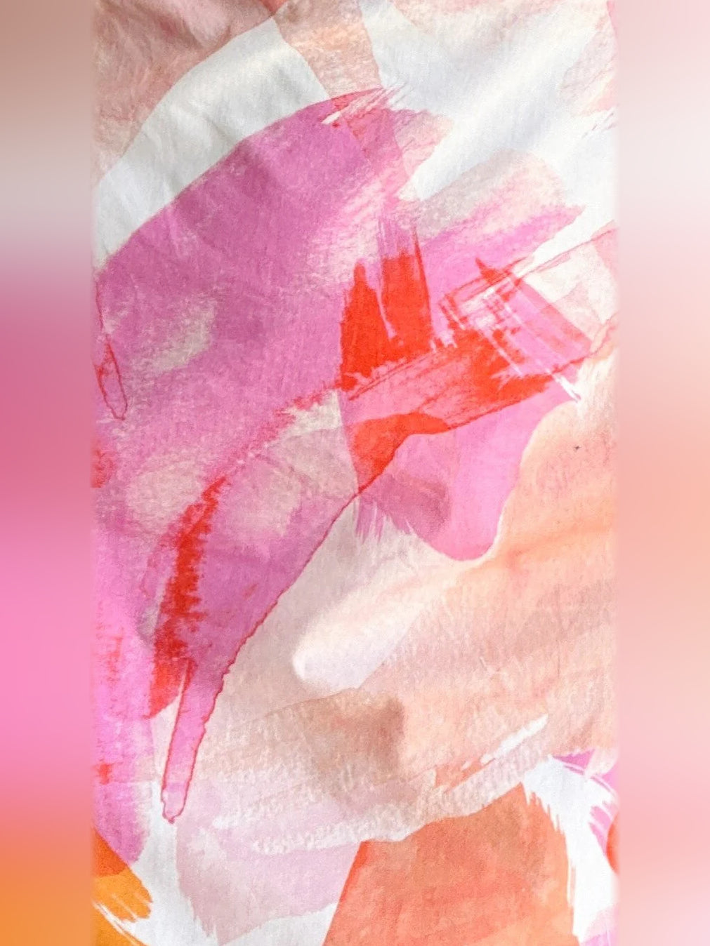 Close-up of pink, orange, and white abstract print fabric on a mini dress