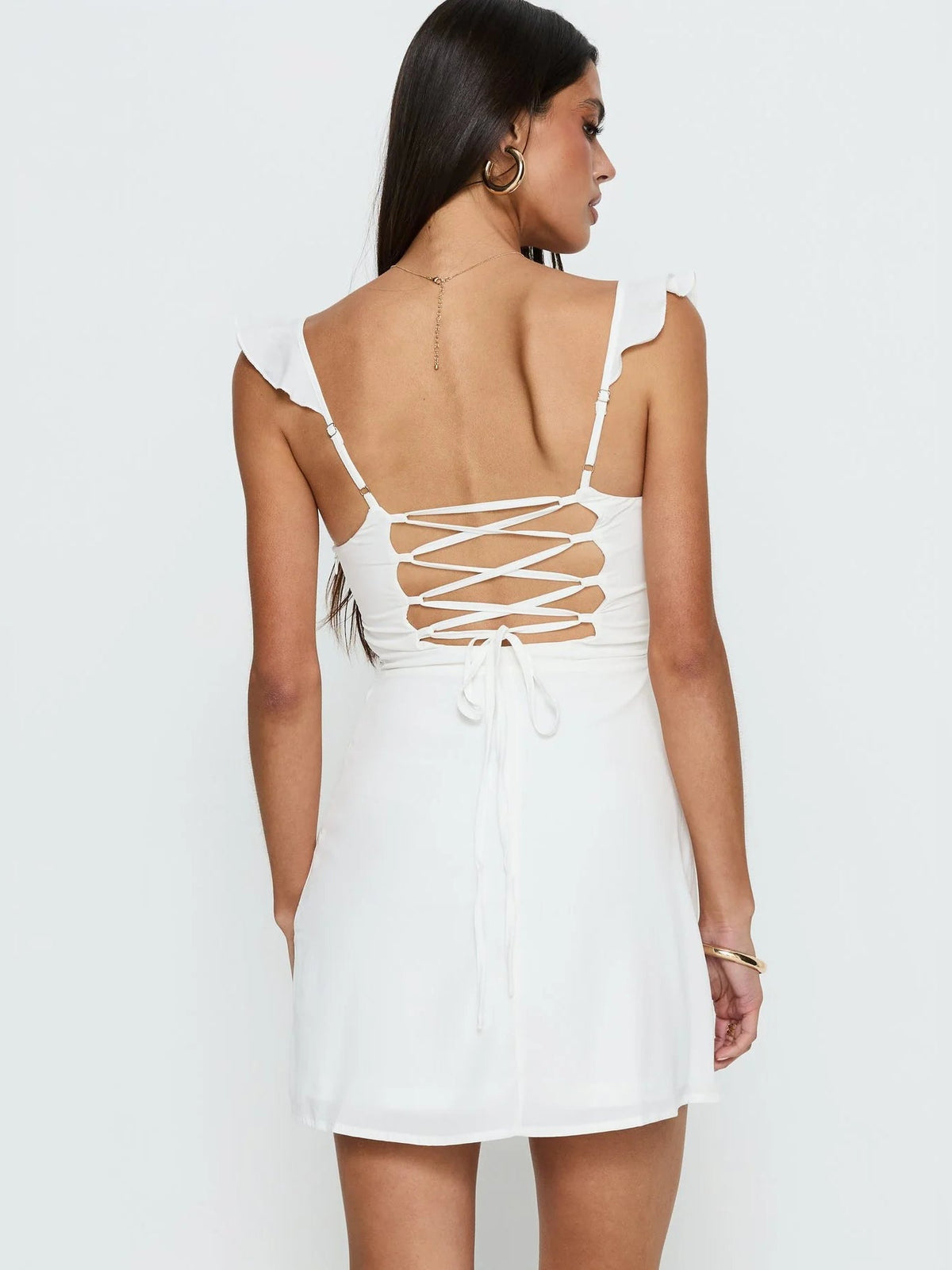 White mini dress with open back and crisscross lace-up ties