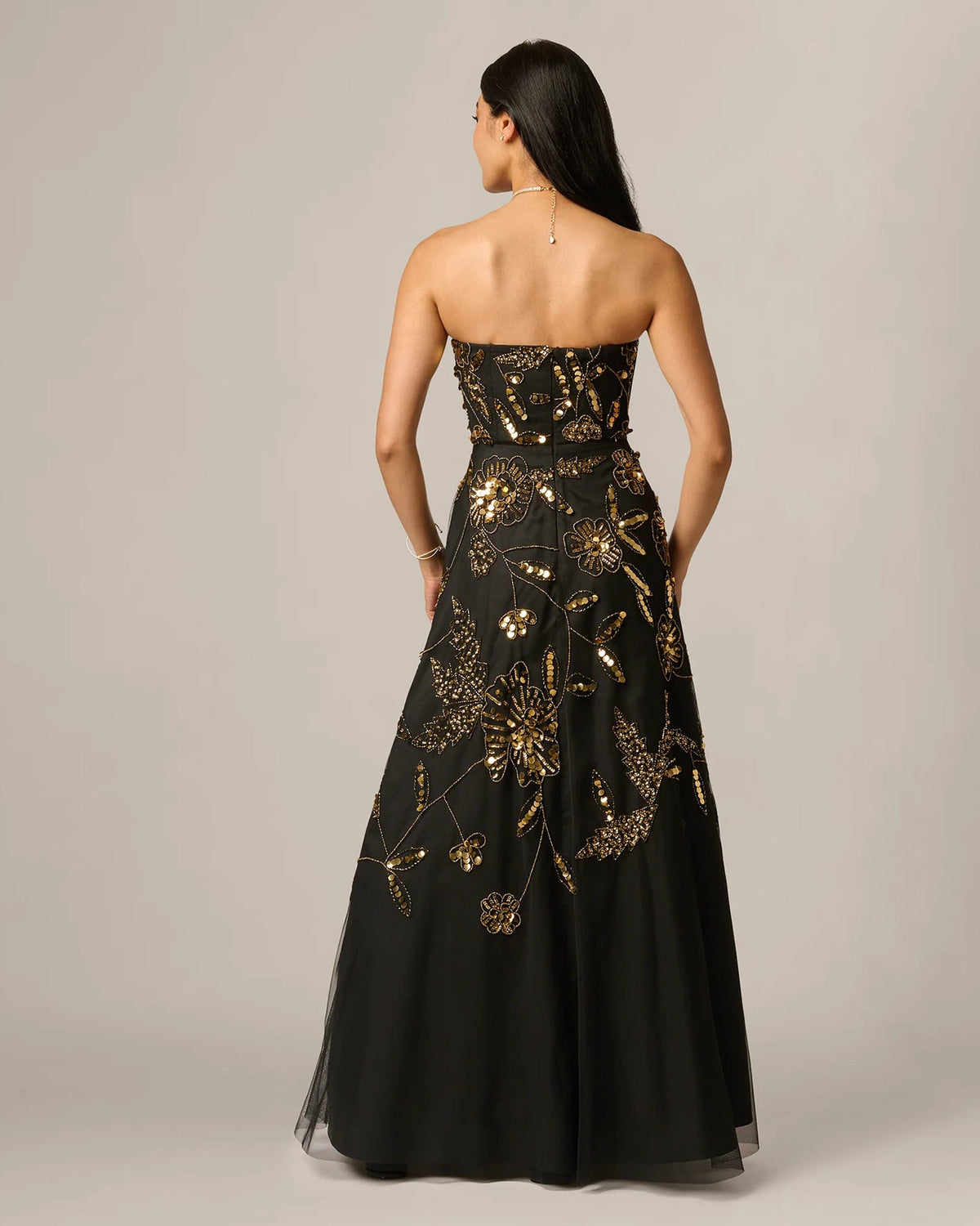 Black strapless maxi dress with open back and gold floral beadwork