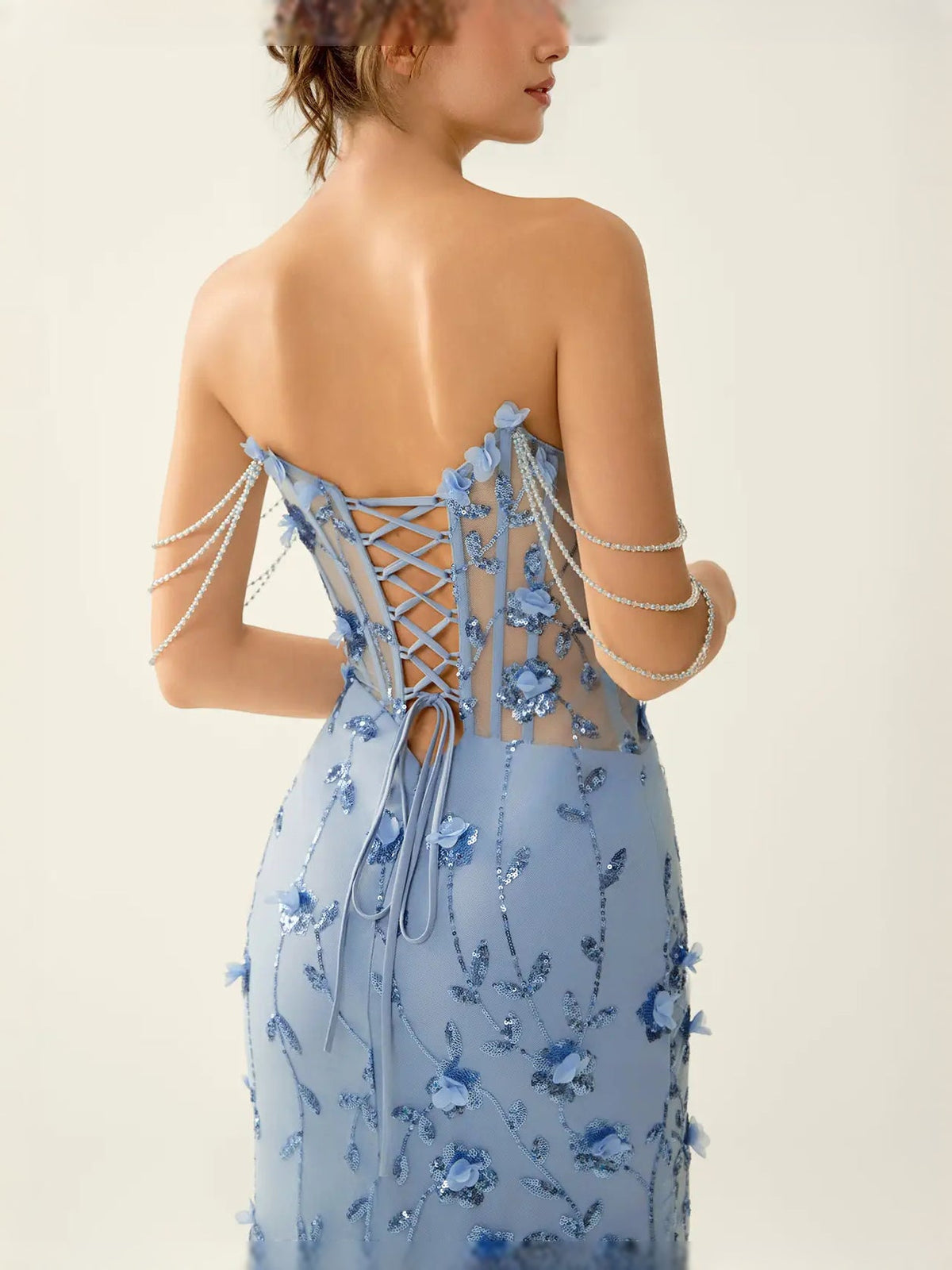 Light blue open-back corset prom dress with floral appliques, lace-up detail and long skirt