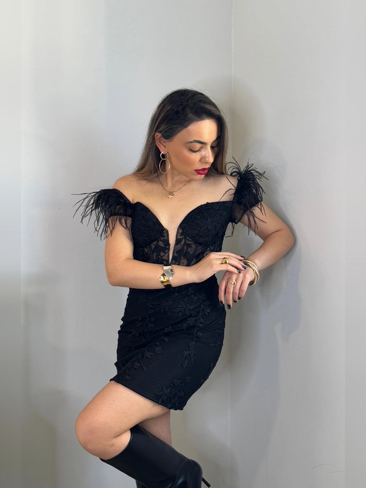 Black corset V-neck mini dress with feather off-shoulder sleeves, close-up