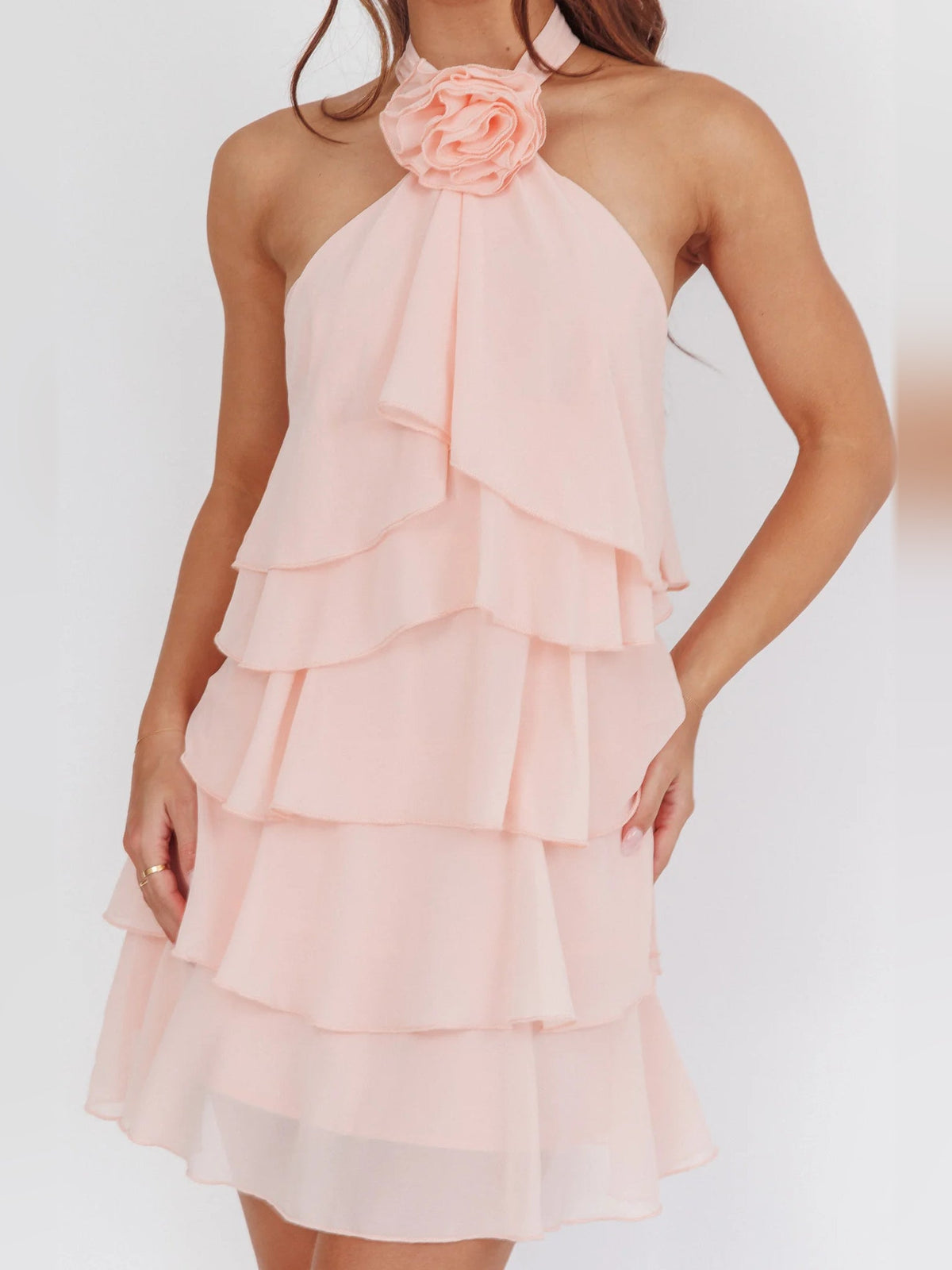 Pink halter mini dress with layered ruffles and rose-shaped neck decoration