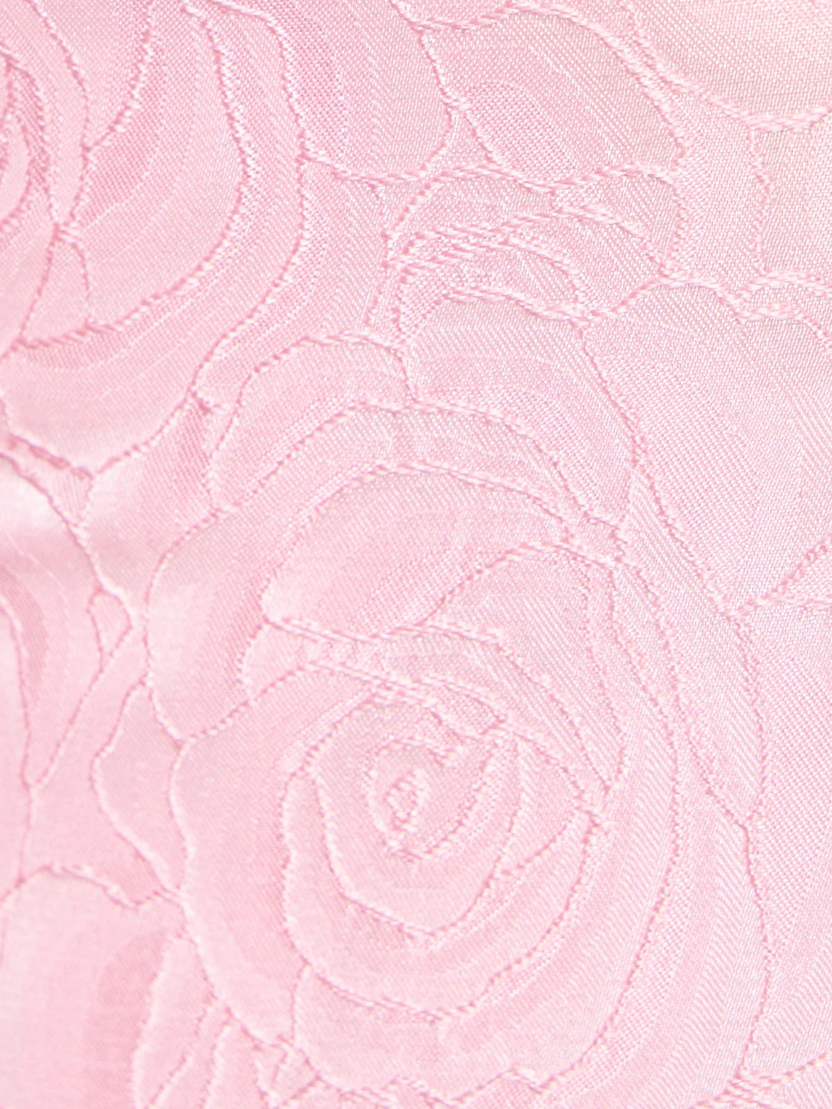 Close-up of pink textured fabric with embroidered swirl rose pattern