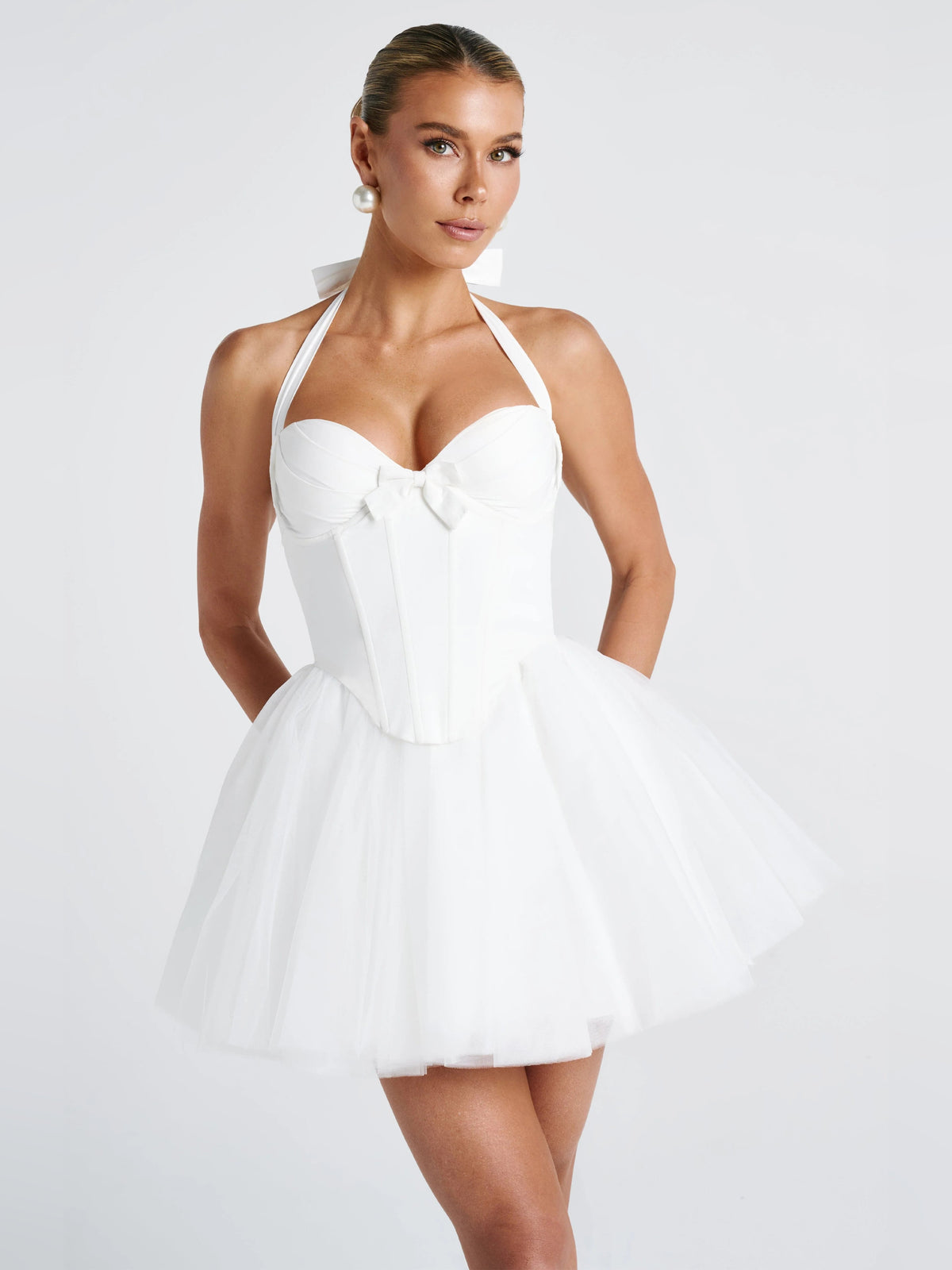 Ivory halter mini dress with sweetheart neckline, bow accents, and layered tulle skirt