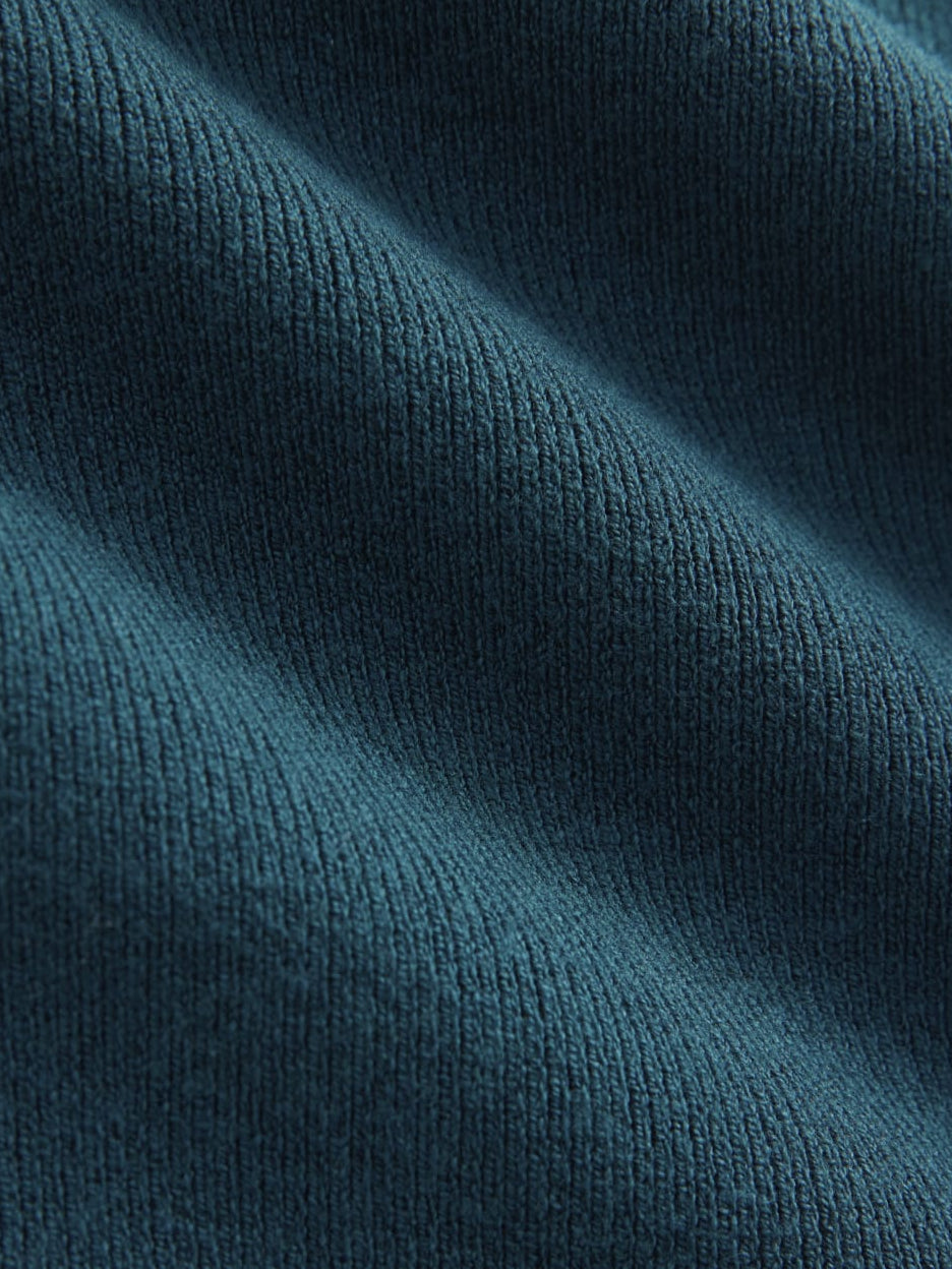 Teal knit fabric close-up with fine ribbed texture