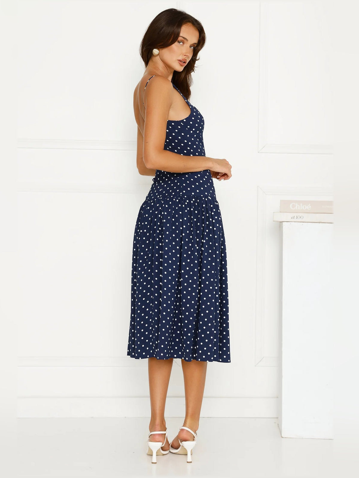 Navy polka dot midi dress side view with sleeveless bodice and flared skirt