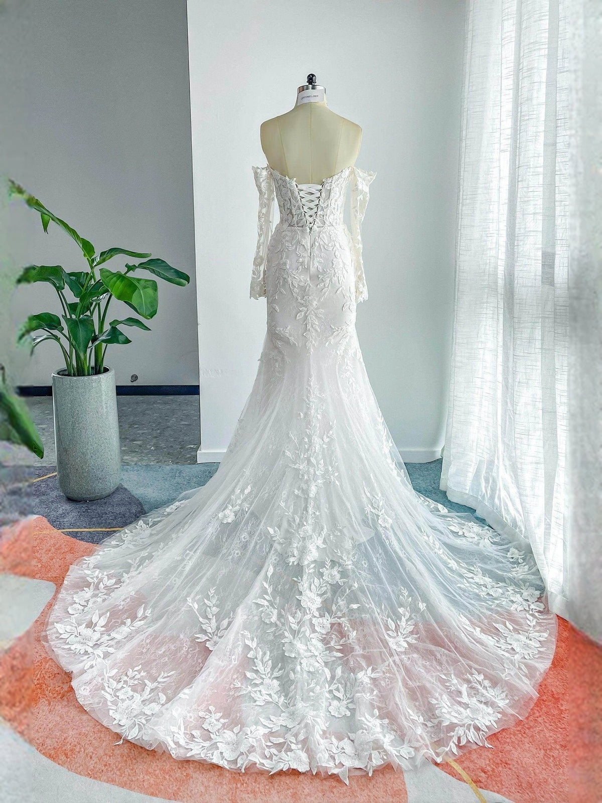 Ivory floor-length mermaid wedding gown with floral lace top and layered tulle hem
