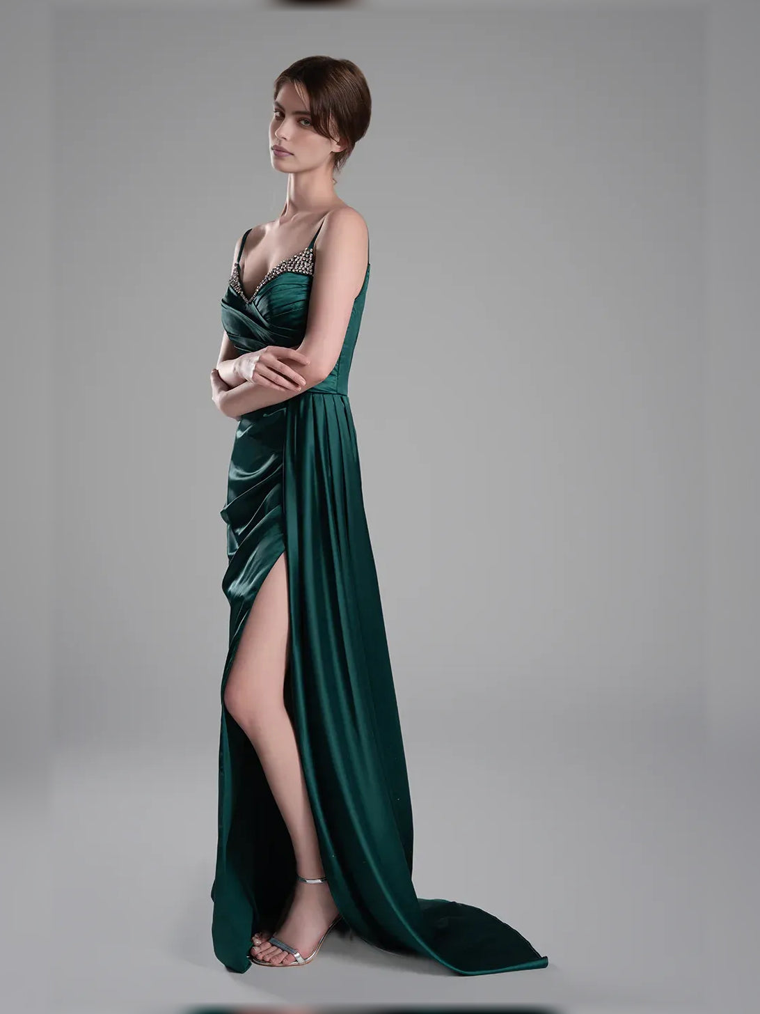 Peacock green satin V-neck formal gown with spaghetti straps, ruching, and leg slit.