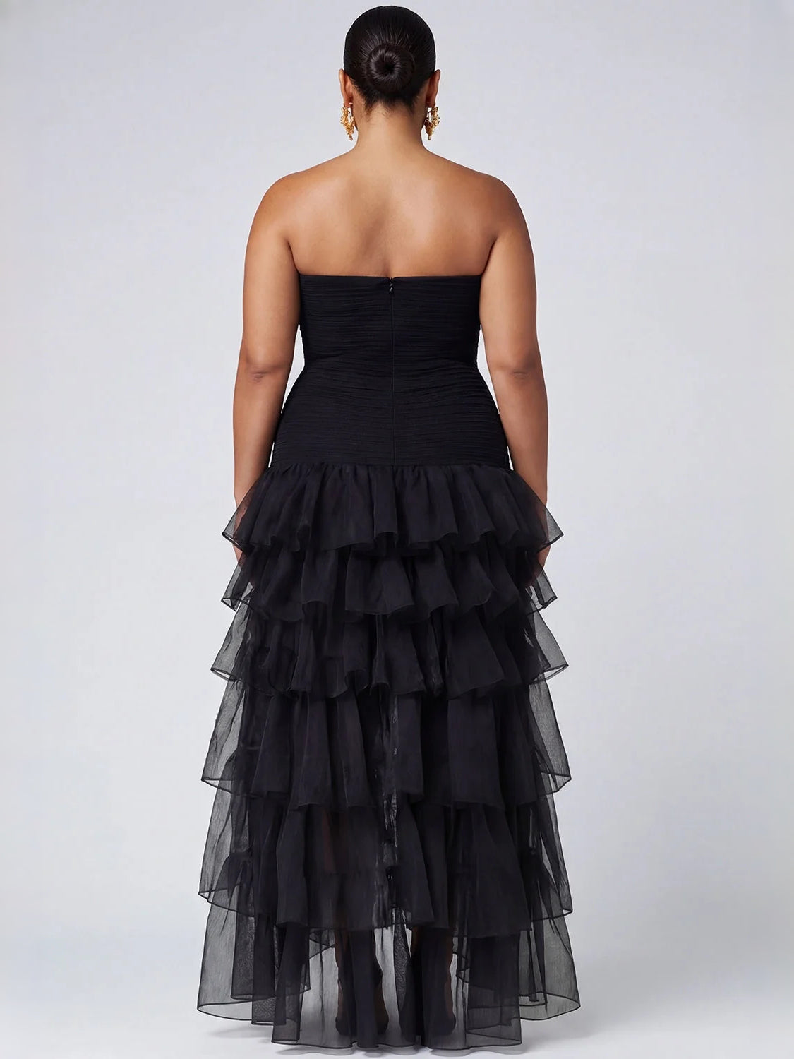 Back view: black strapless A-line prom dress with tiered ruffles and high-low hem