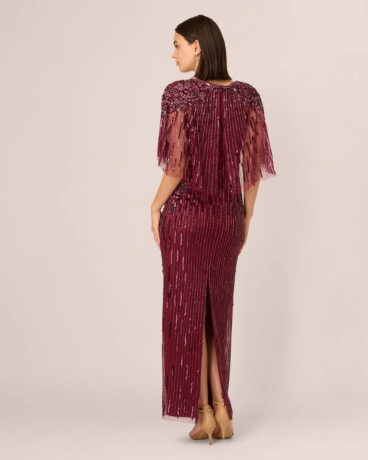Burgundy sequined sheath maxi dress from back view with flowing fringe sleeves