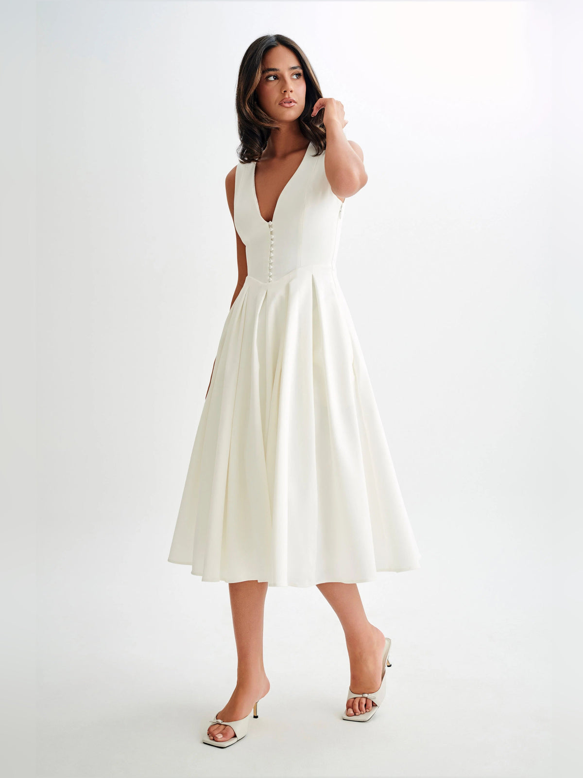 White sleeveless midi formal dress with V-neckline and full pleated skirt