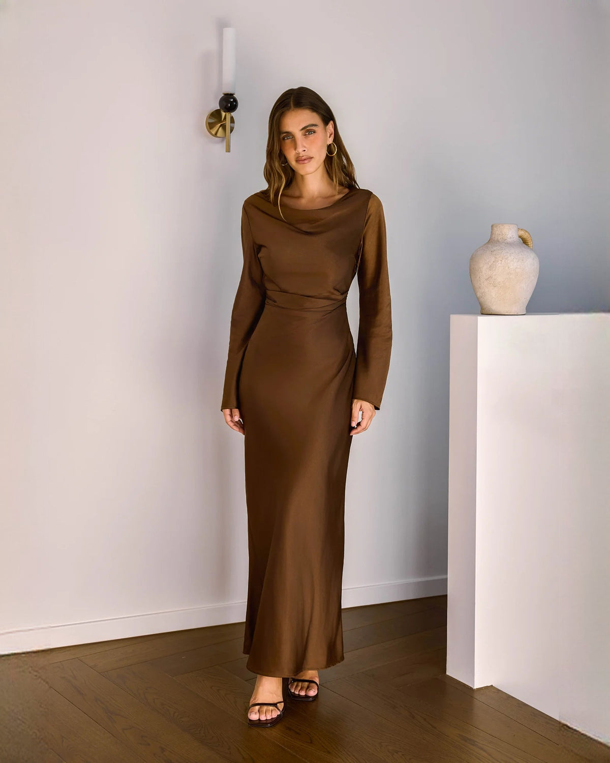 Chocolate brown satin fitted maxi dress with long sleeves and subtle side drape at waist