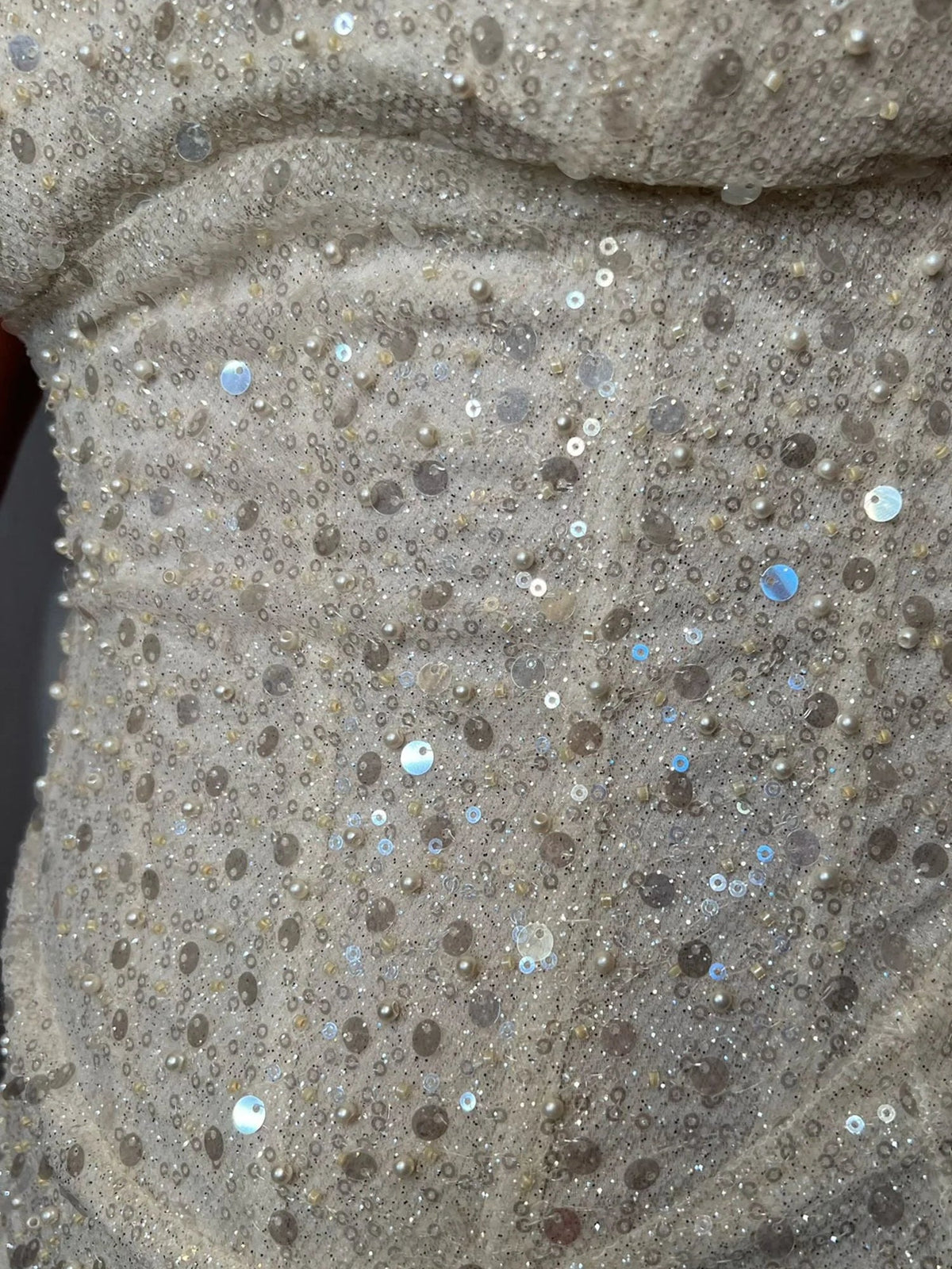 Close-up of cream beaded fabric with sparkling sequin details